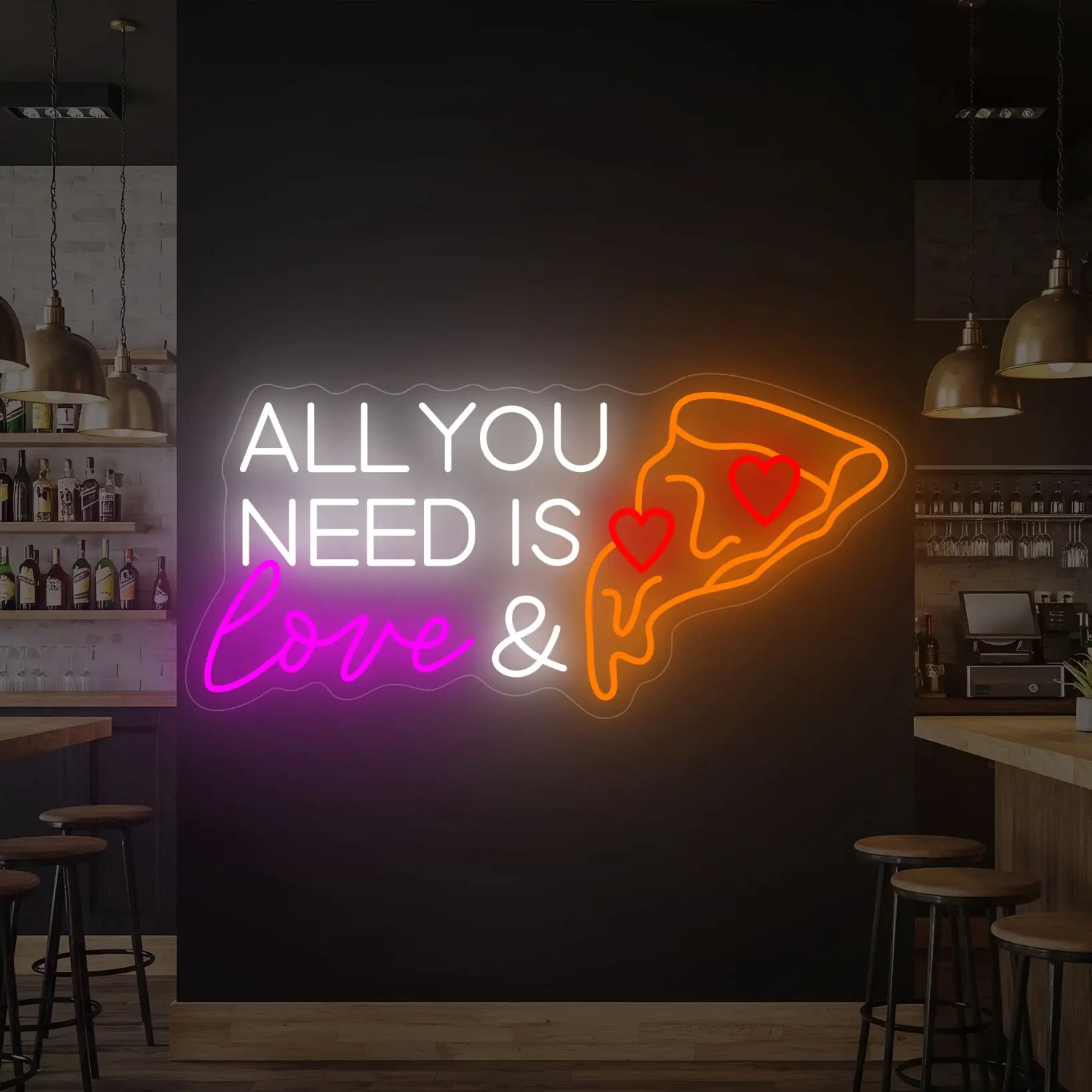 Photo of the 'ALL YOU NEED IS LOVE & PIZZA' neon sign glowing in multi-color against a styled interior wall.