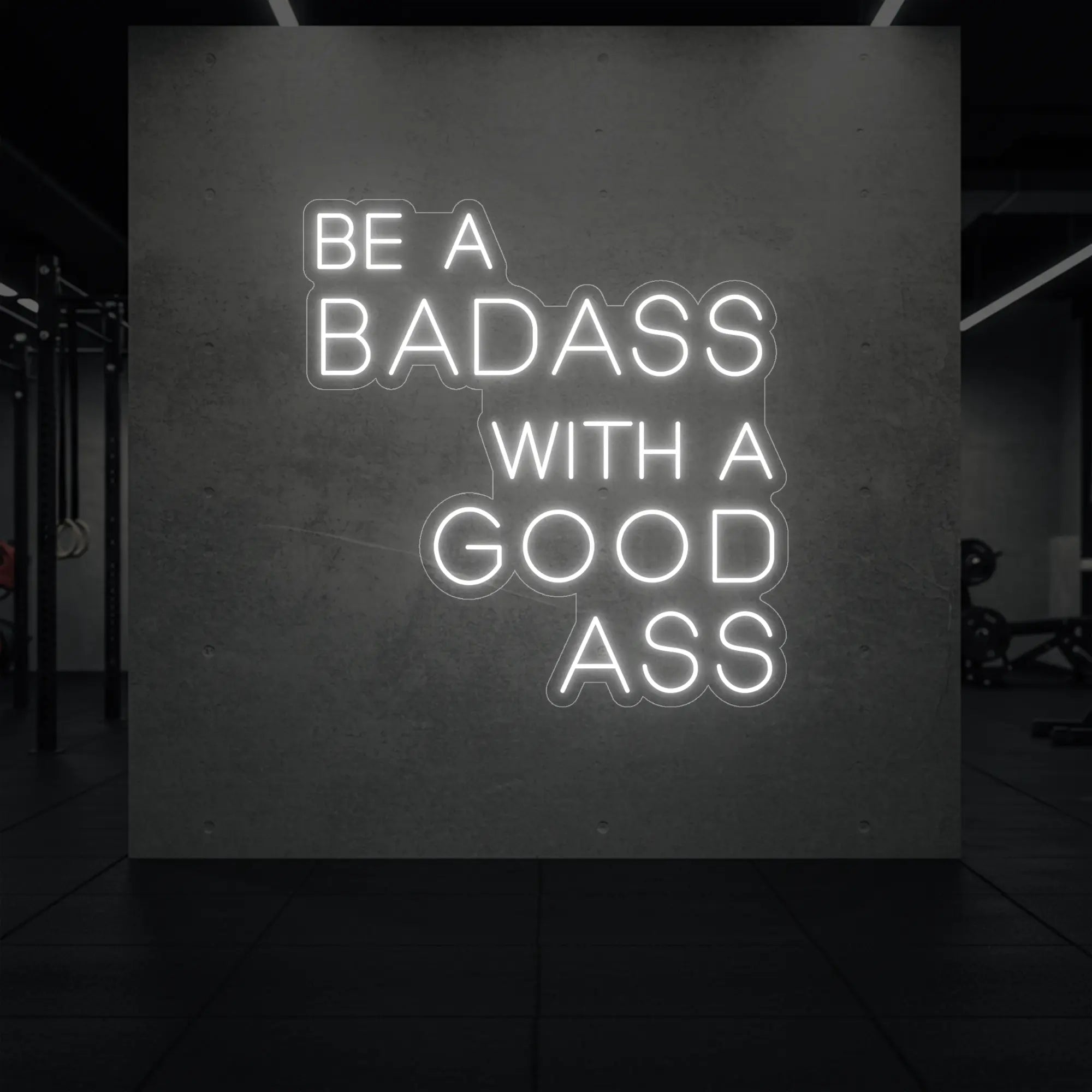 'Be a Badass With a Good Ass' neon sign glowing in cool white against a styled interior wall.