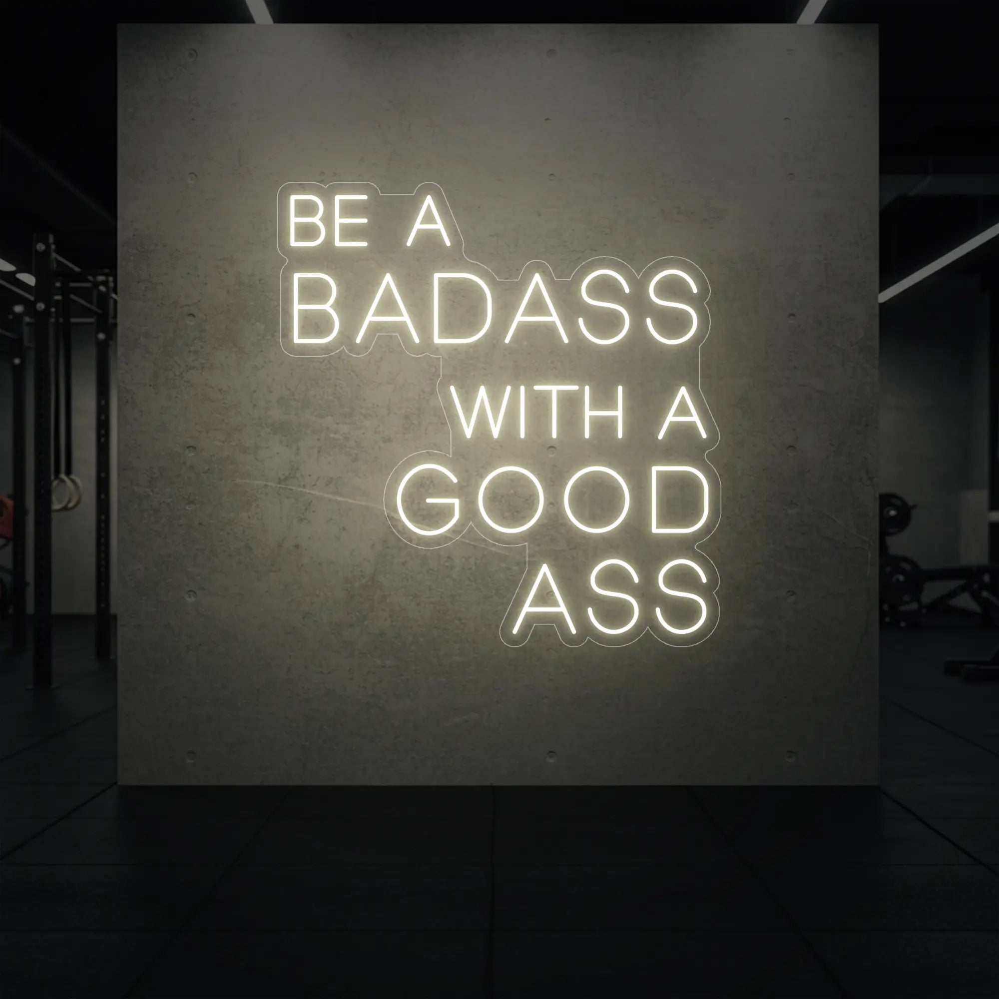 'Be a Badass With a Good Ass' neon sign glowing in warm white against a styled interior wall.