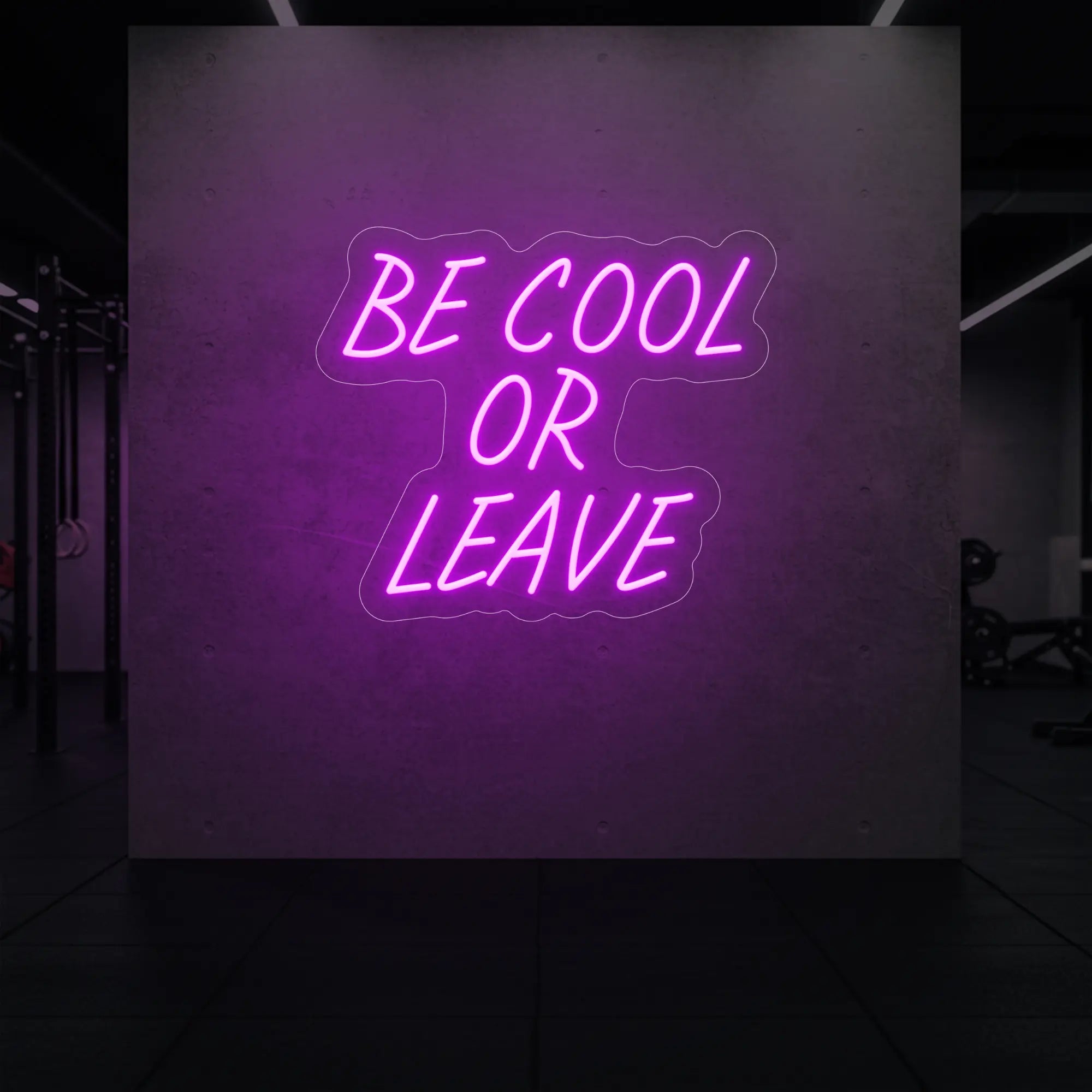 'Be Cool or Leave' neon sign glowing in deep pink against a styled interior wall.