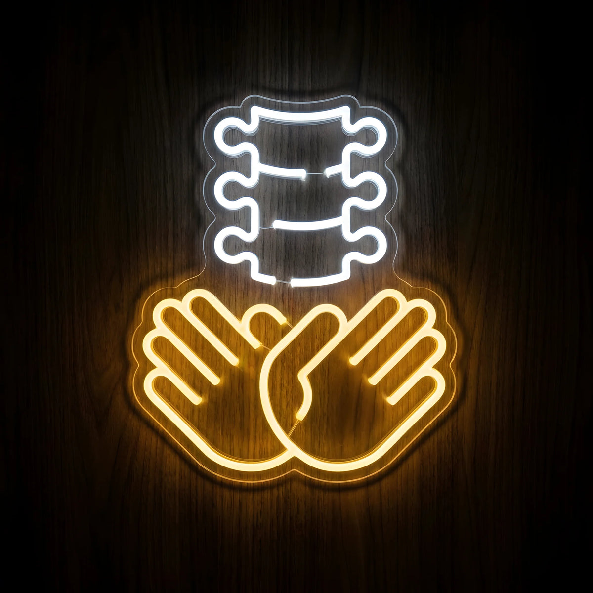 Chiropractic Spine Care LED neon sign featuring a cool white spinal column above two golden-yellow supportive hands on clear acrylic backing for chiropractic clinic wall decor.