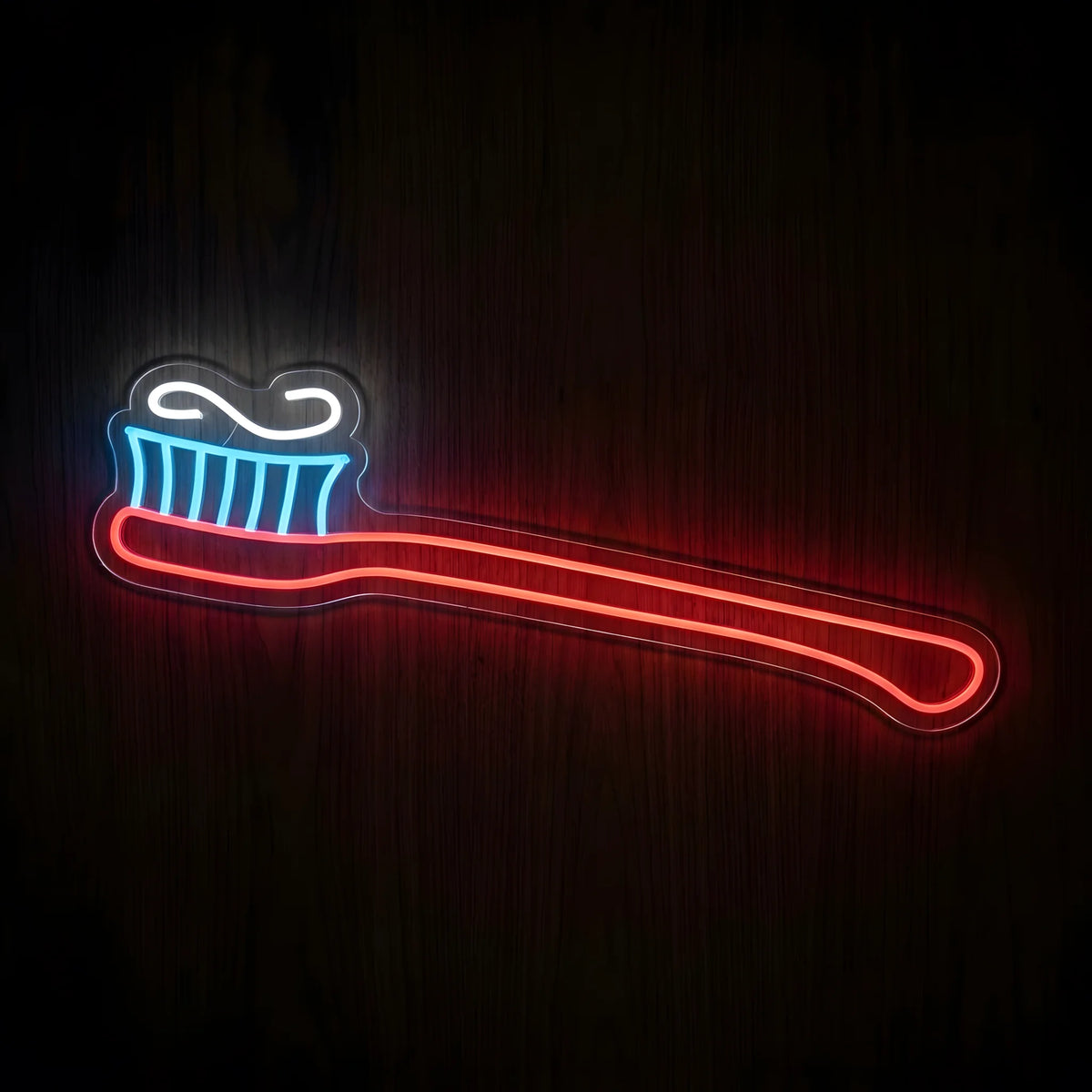 Colorful Toothbrush LED neon sign featuring a glowing red toothbrush handle, cyan-blue bristles, and cool white toothpaste swirl on clear acrylic backing for dental clinic wall decor.