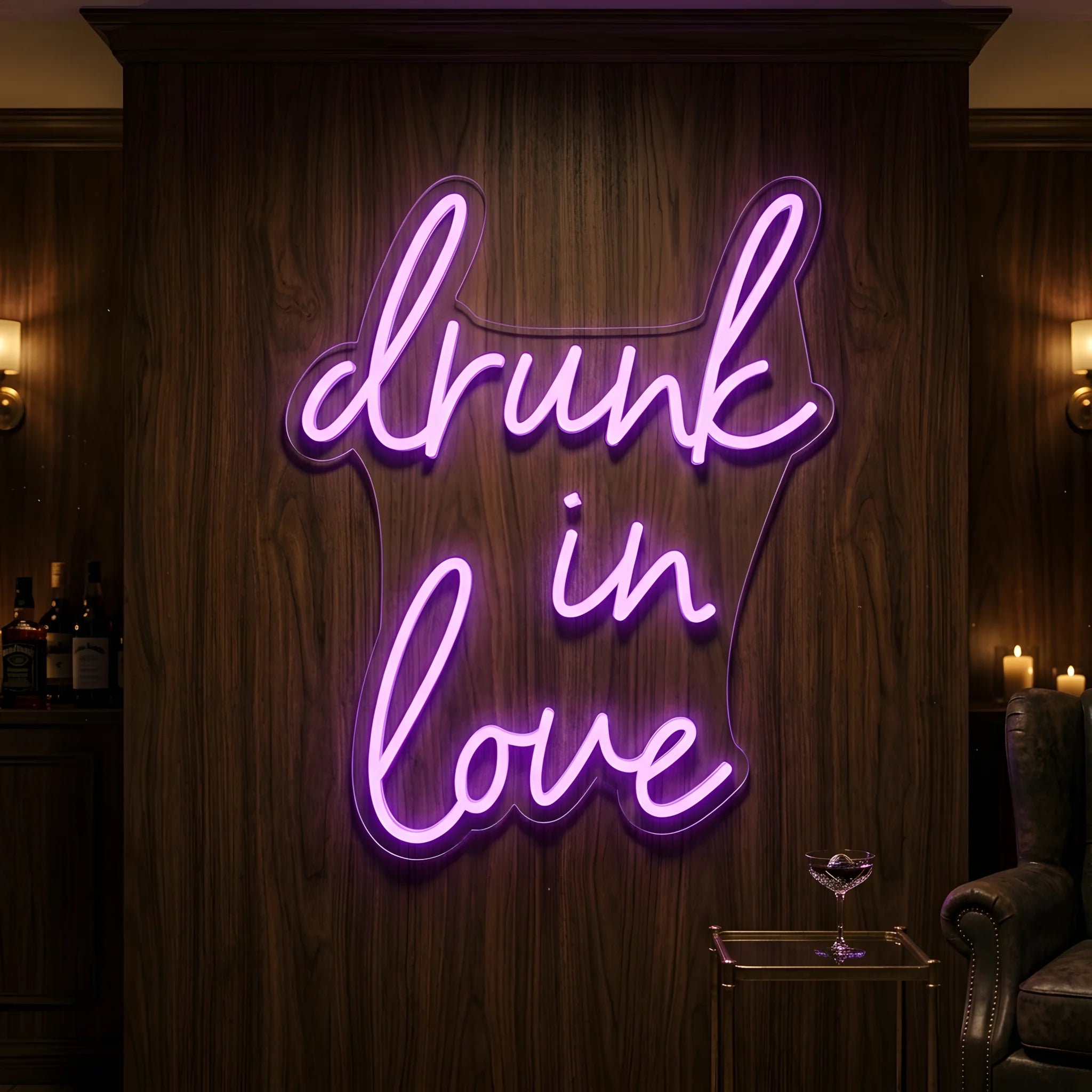 Photo of the 'Drunk in Love' neon sign glowing in purple against a styled interior wall.