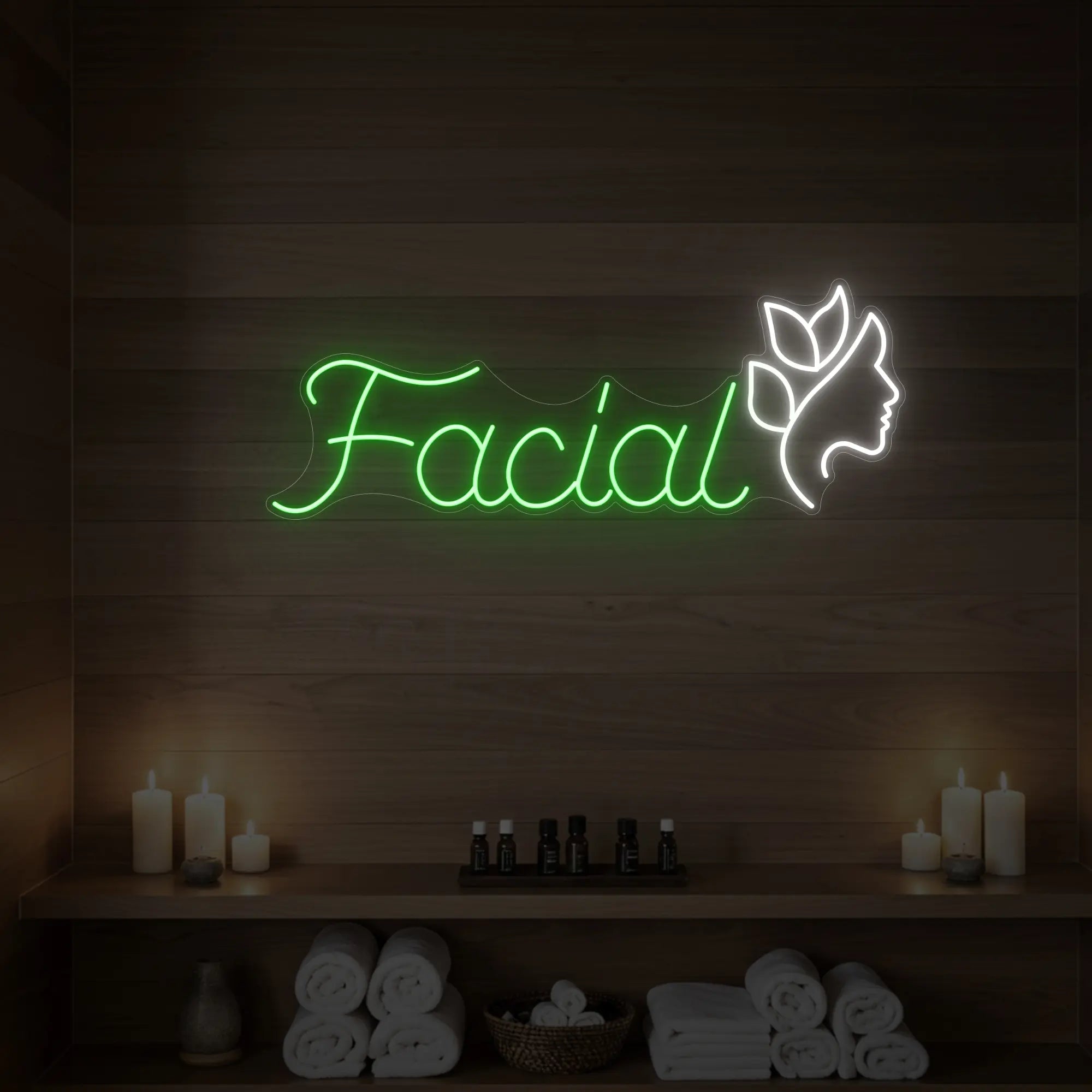 Photo of the 'Facial' neon sign with a botanical face silhouette glowing in green against a styled interior wall.