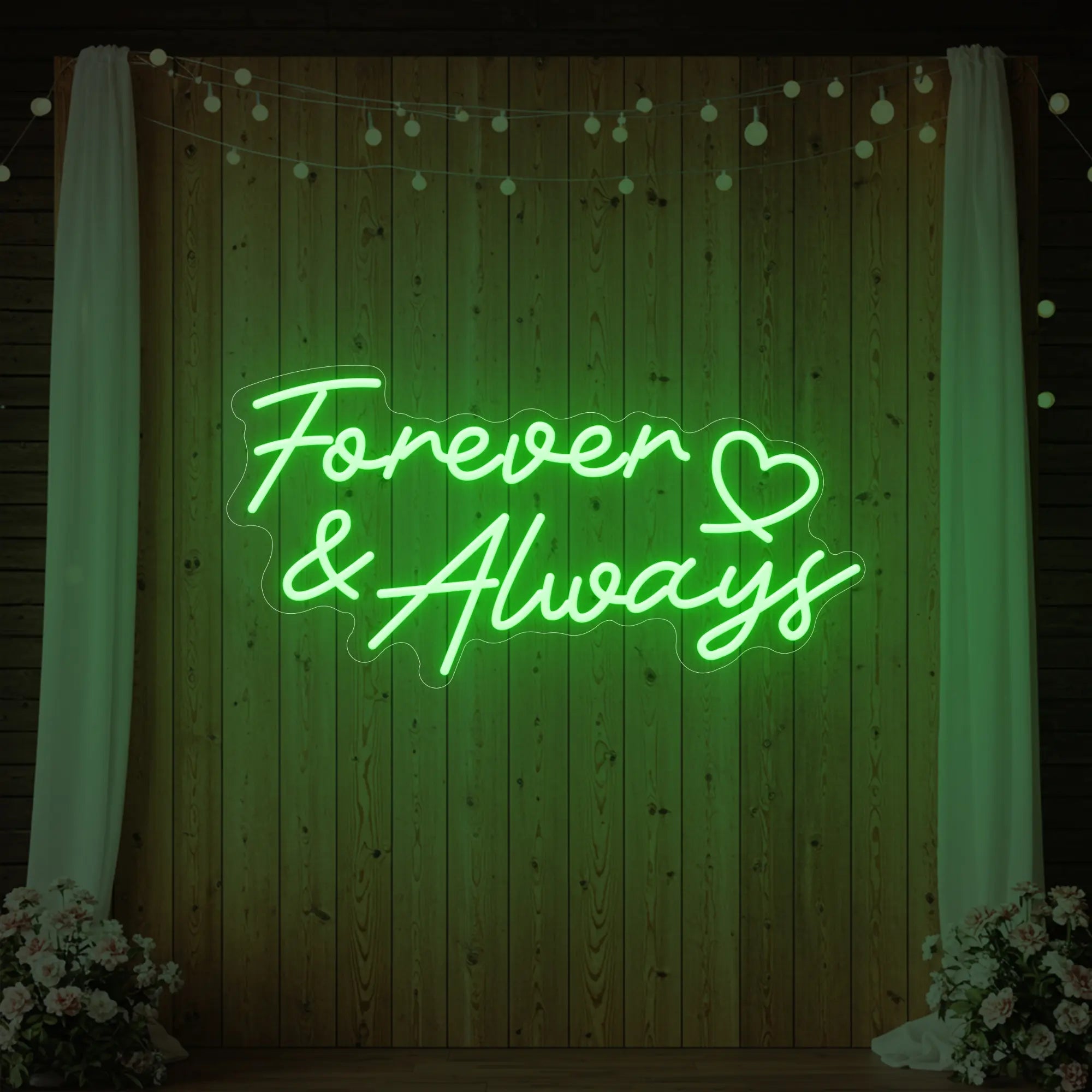 Photo of the 'Forever & Always' neon sign glowing in green against a styled interior wall.