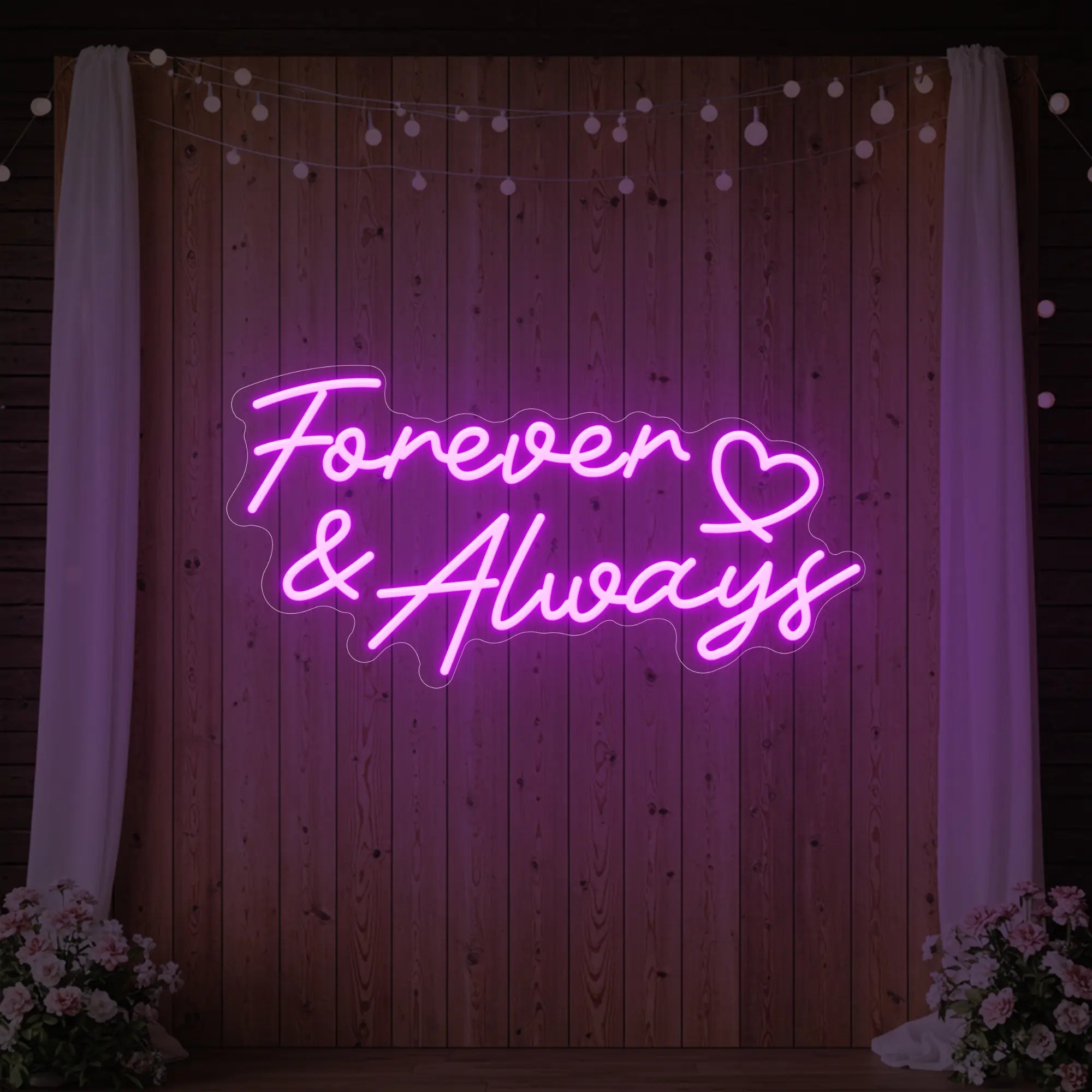 Photo of the 'Forever & Always' neon sign glowing in deep pink against a styled interior wall.