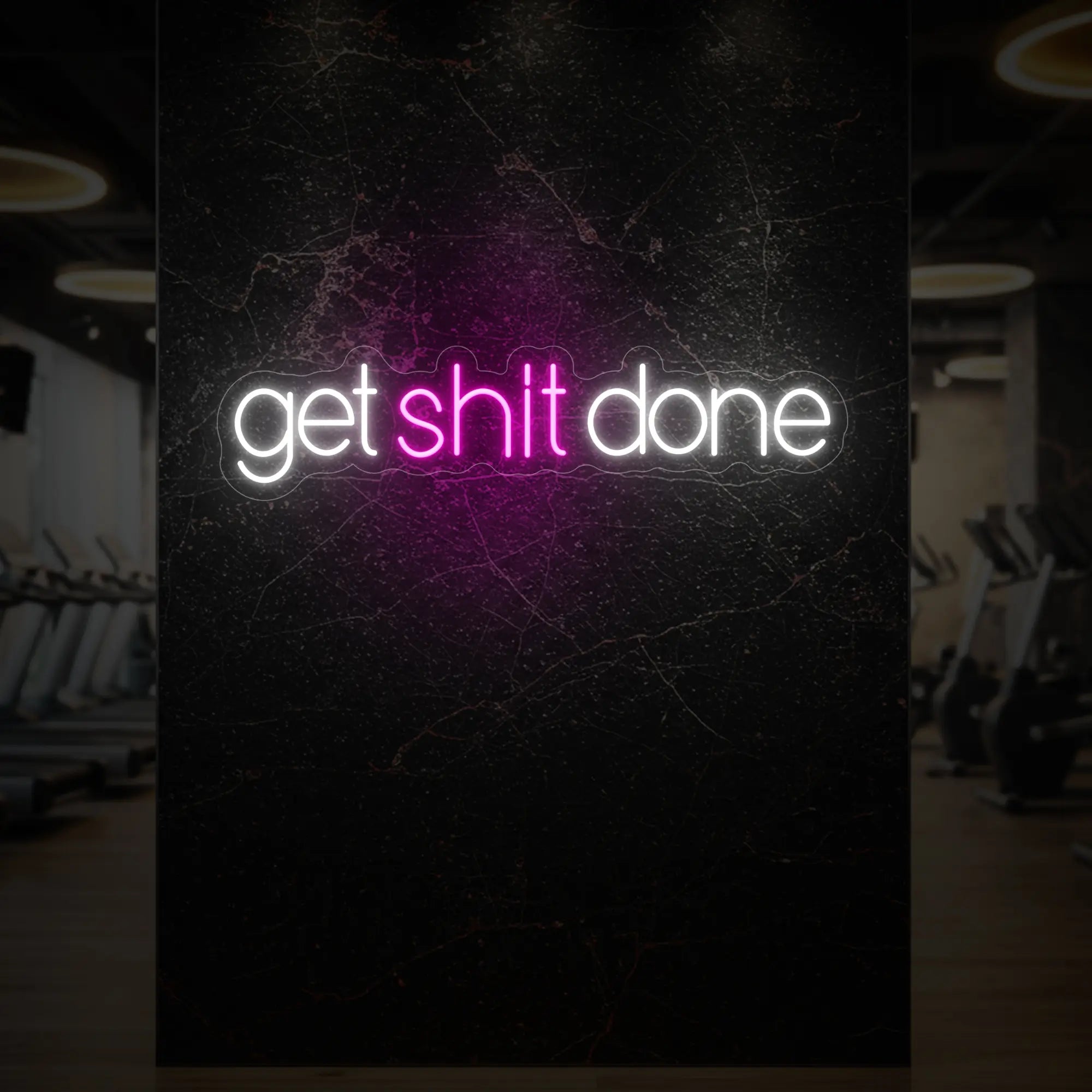 'Get Shit Done' neon sign glowing in light pink against a styled interior wall.