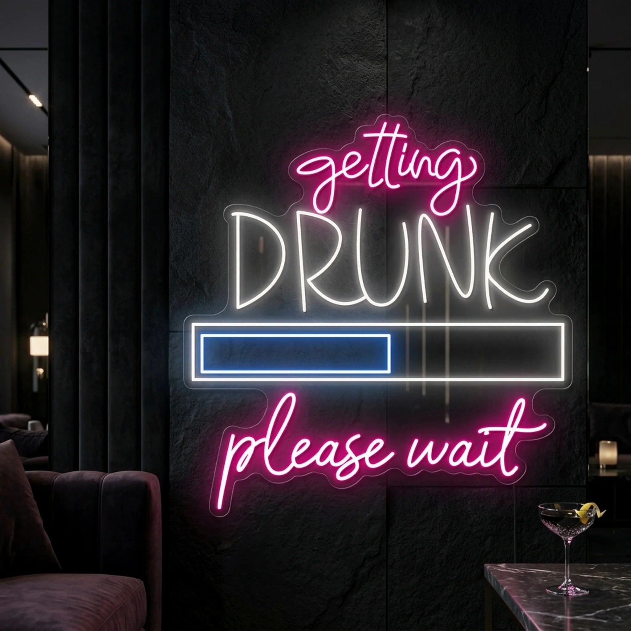 Photo of the 'Getting Drunk Please Wait' neon sign glowing in multi-color against a styled interior wall.
