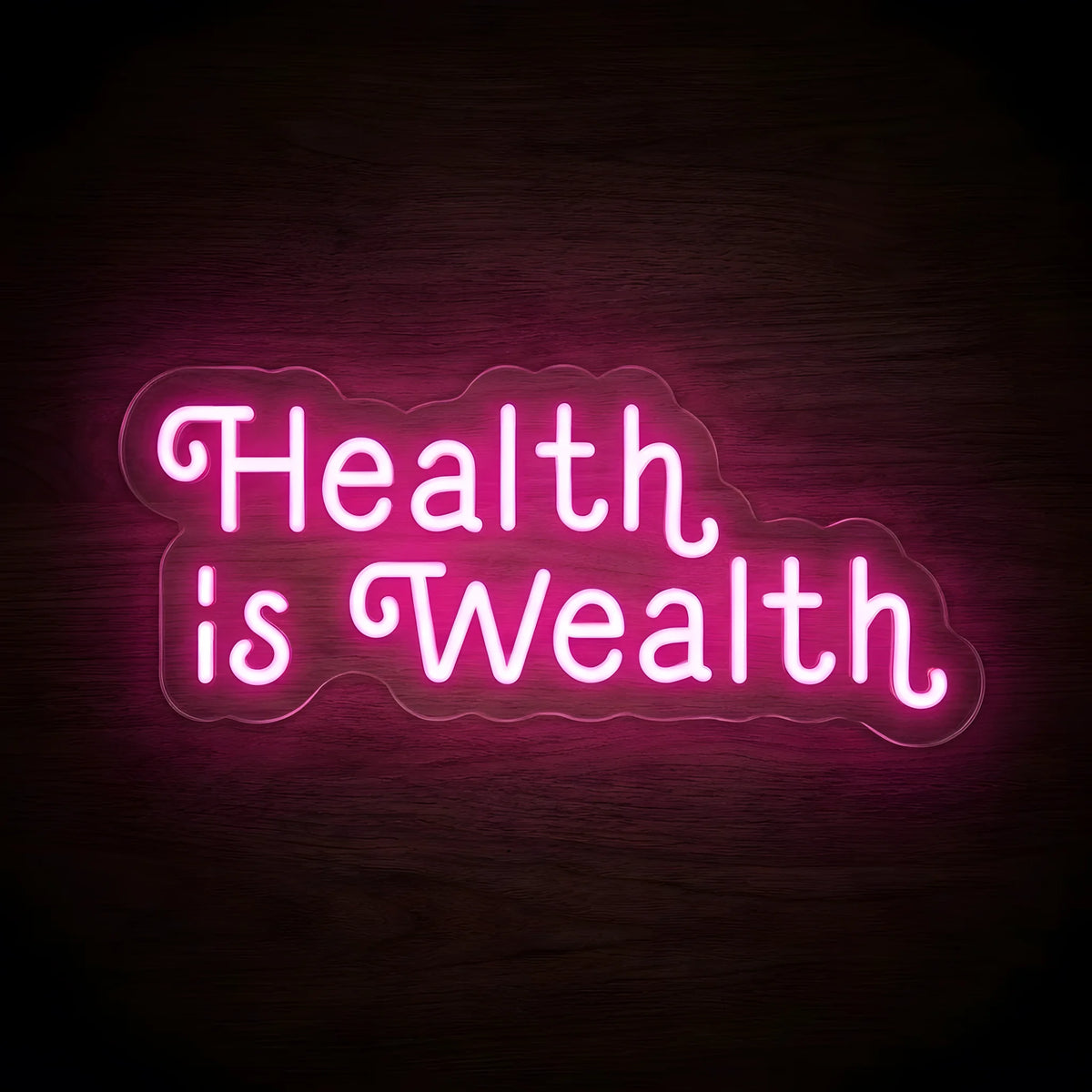 Health Is Wealth Script LED Neon Sign featuring glowing pink decorative lettering arranged across two lines on clear cut-to-shape acrylic backing against a dark wooden wall.