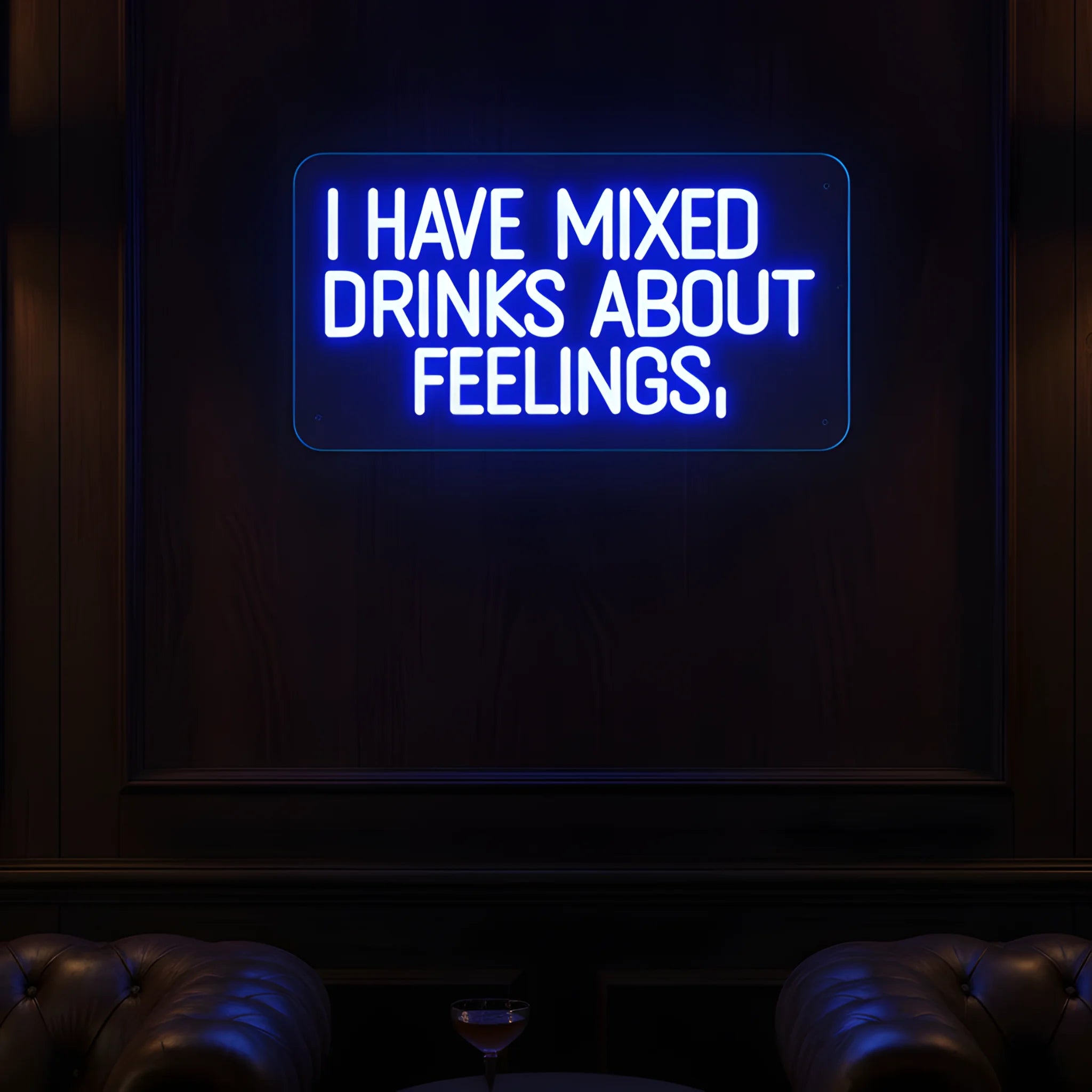 Photo of the 'I Have Mixed Drinks About Feelings' neon sign glowing in blue against a styled interior wall.