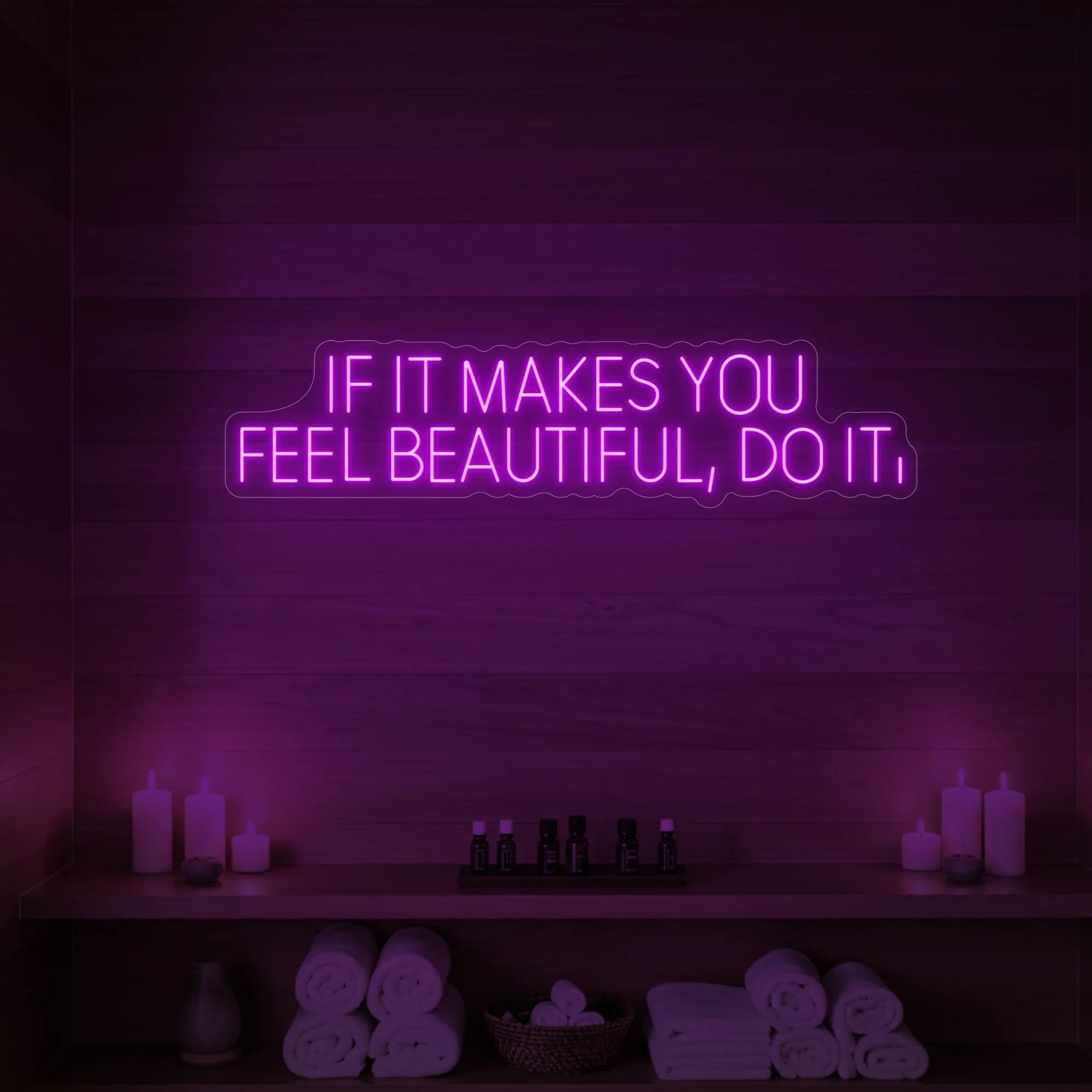 Photo of the 'IF IT MAKES YOU FEEL BEAUTIFUL, DO IT.' neon sign glowing in deep pink against a styled interior wall.