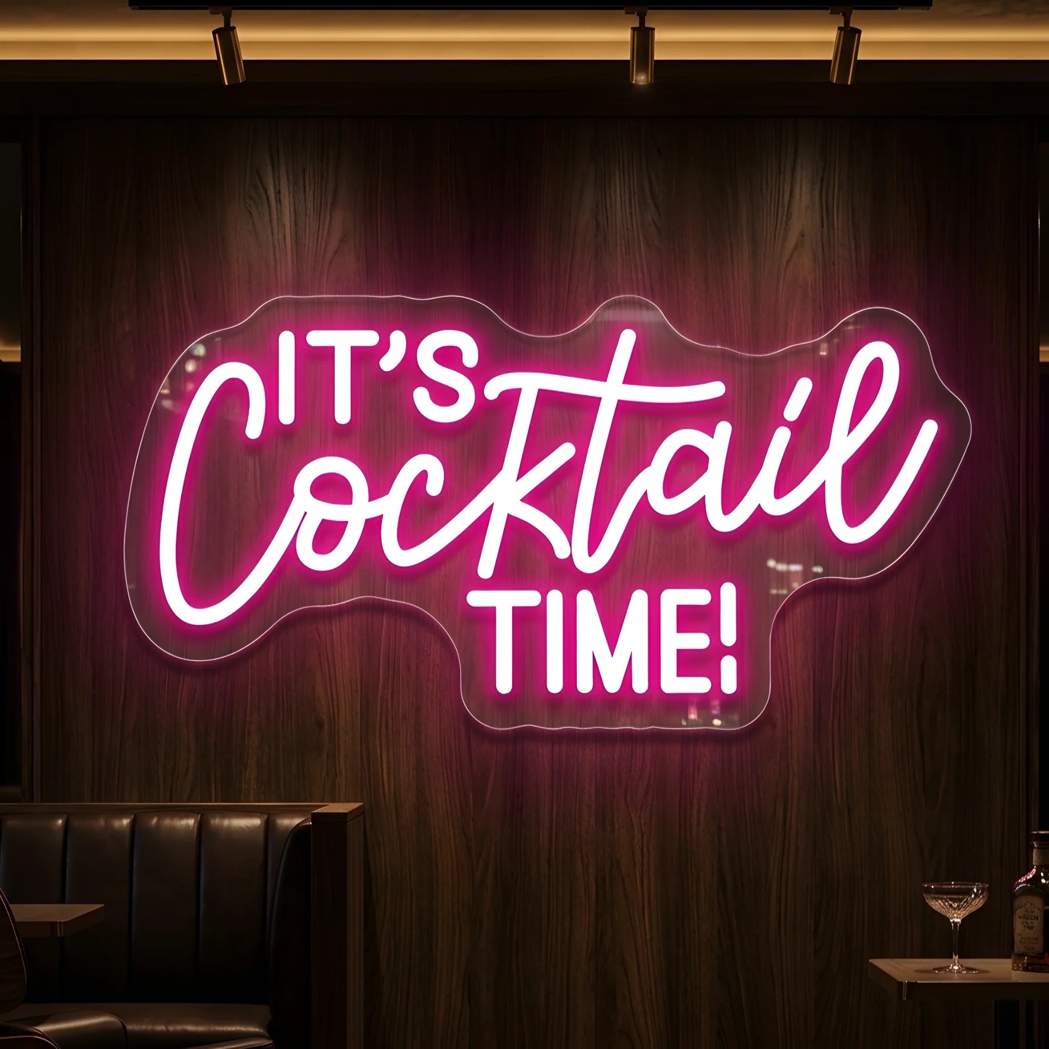 Photo of the 'It’s Cocktail Time!' neon sign glowing in light pink against a styled interior wall.