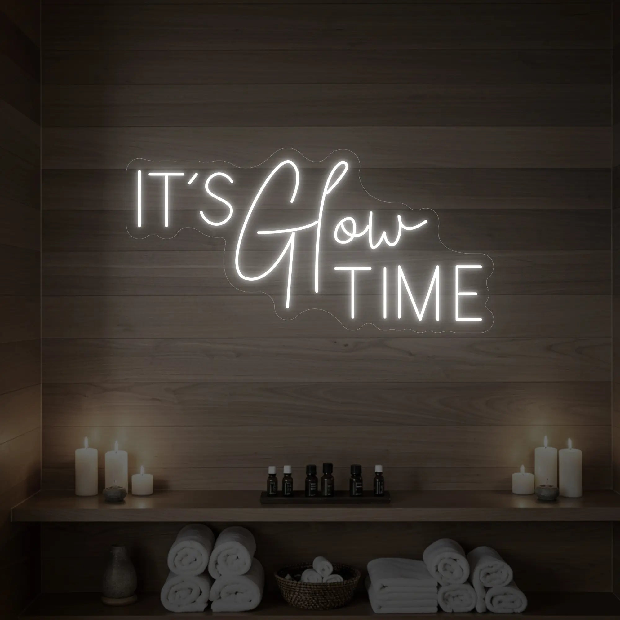 Photo of the 'IT’S Glow TIME' neon sign glowing in cool white against a styled interior wall.