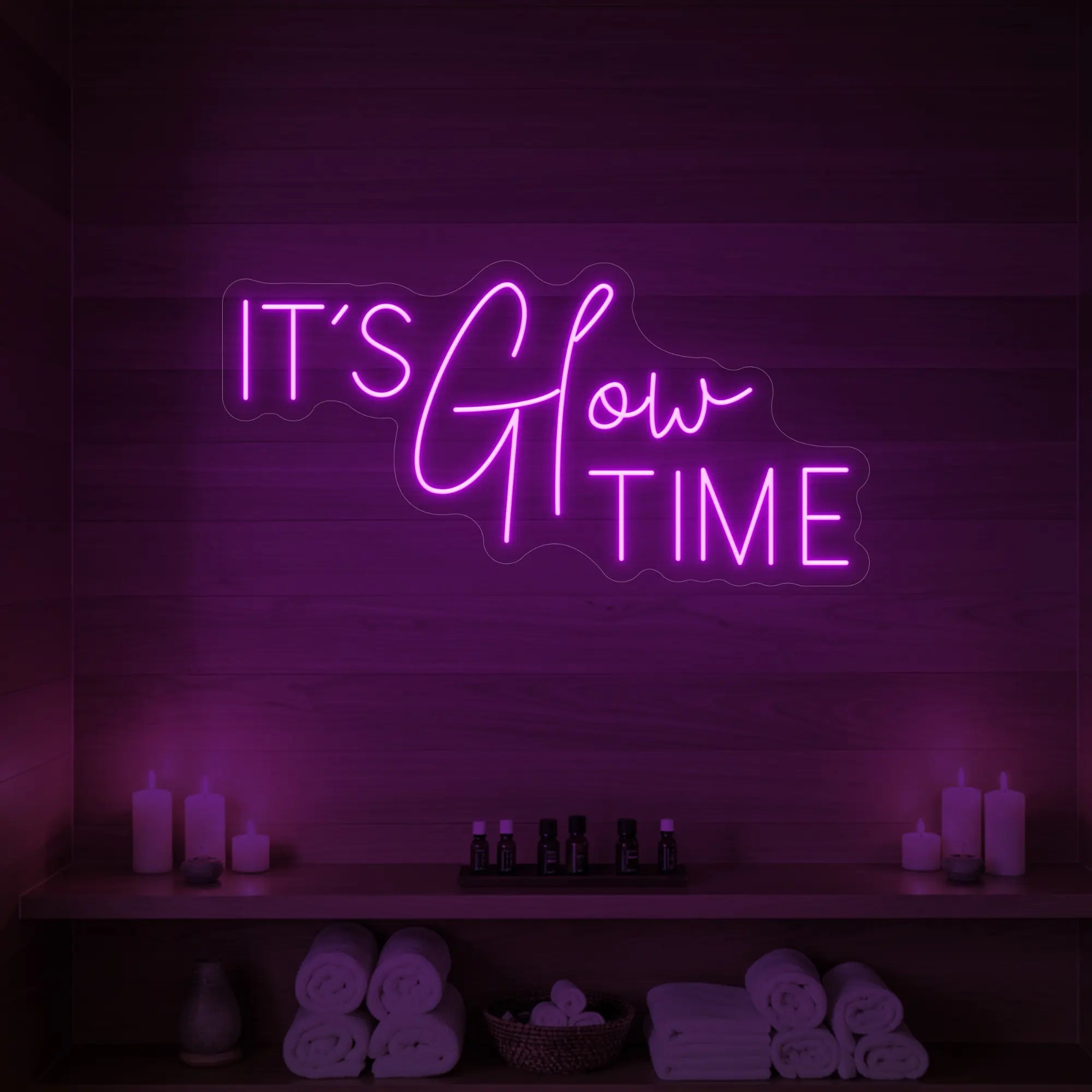 Photo of the 'IT’S Glow TIME' neon sign glowing in deep pink against a styled interior wall.
