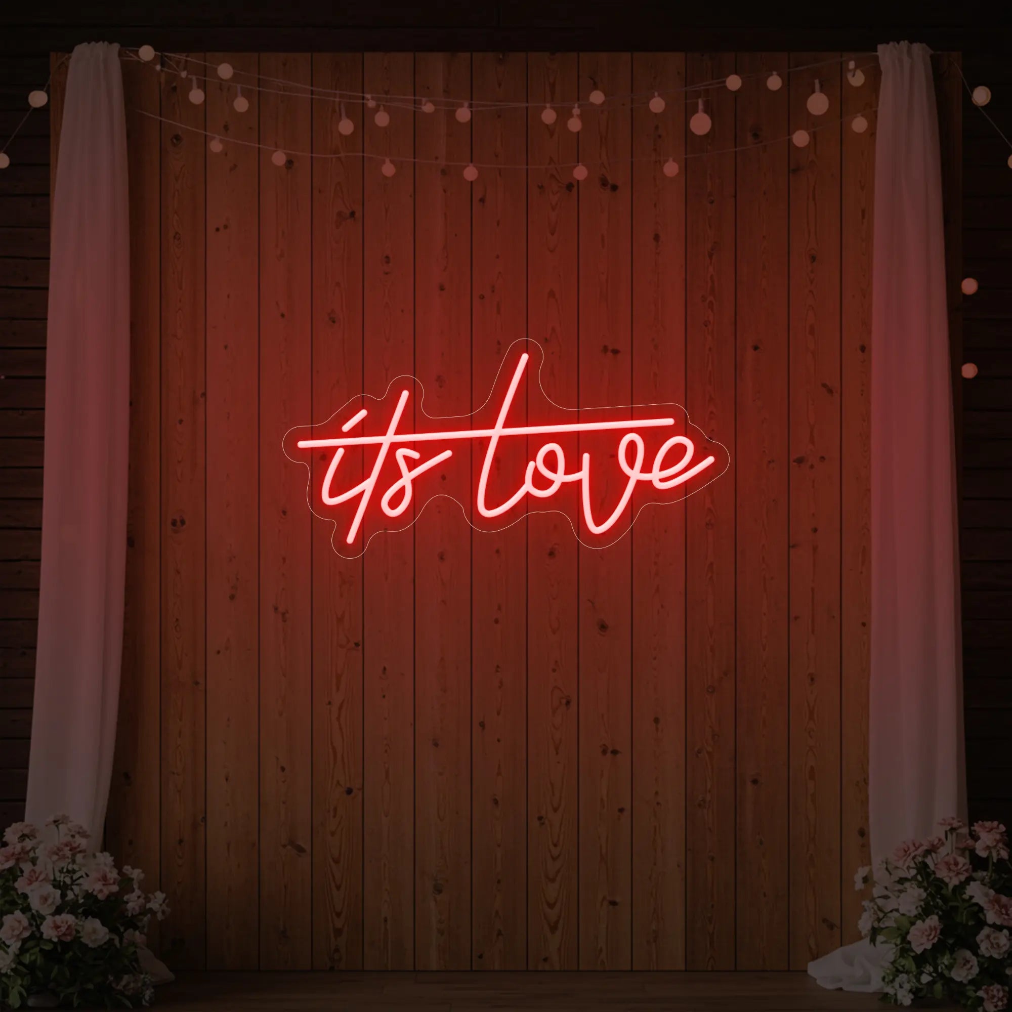 Photo of the 'It’s Love' neon sign glowing in red against a styled interior wall.