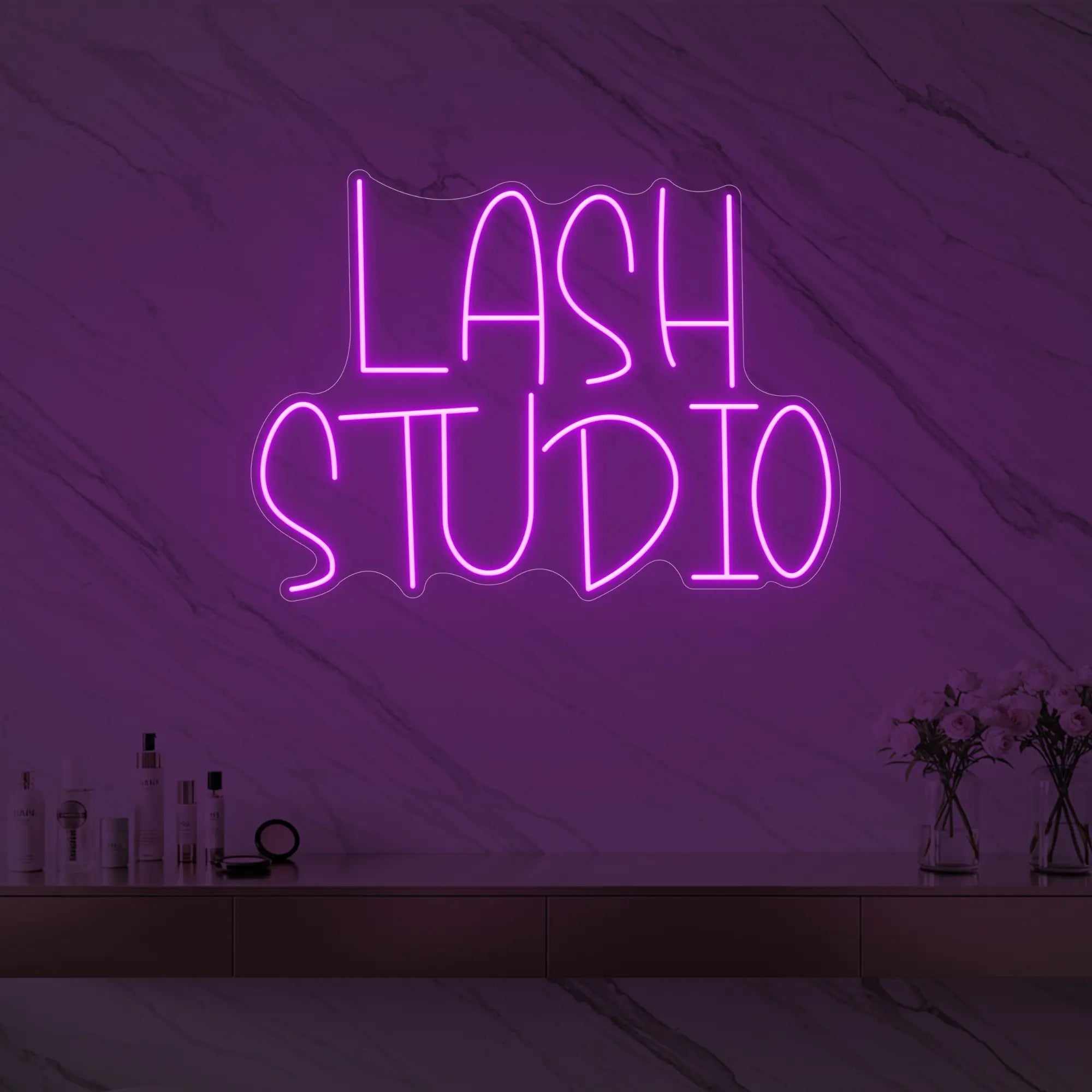 Photo of the 'LASH STUDIO' neon sign glowing in deep pink against a styled interior wall.