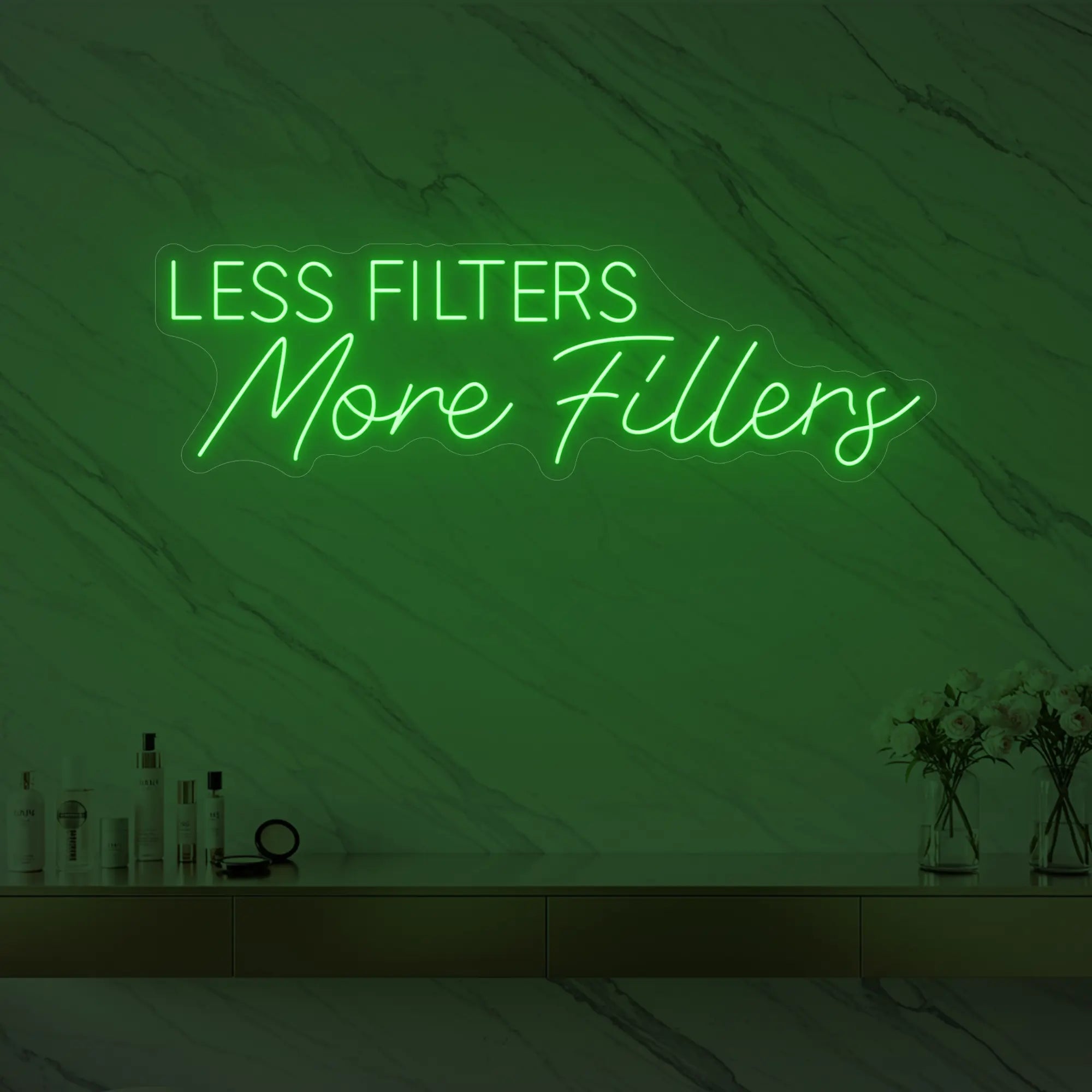 Photo of the 'LESS FILTERS MORE FILLERS' neon sign glowing in green against a marble wall.