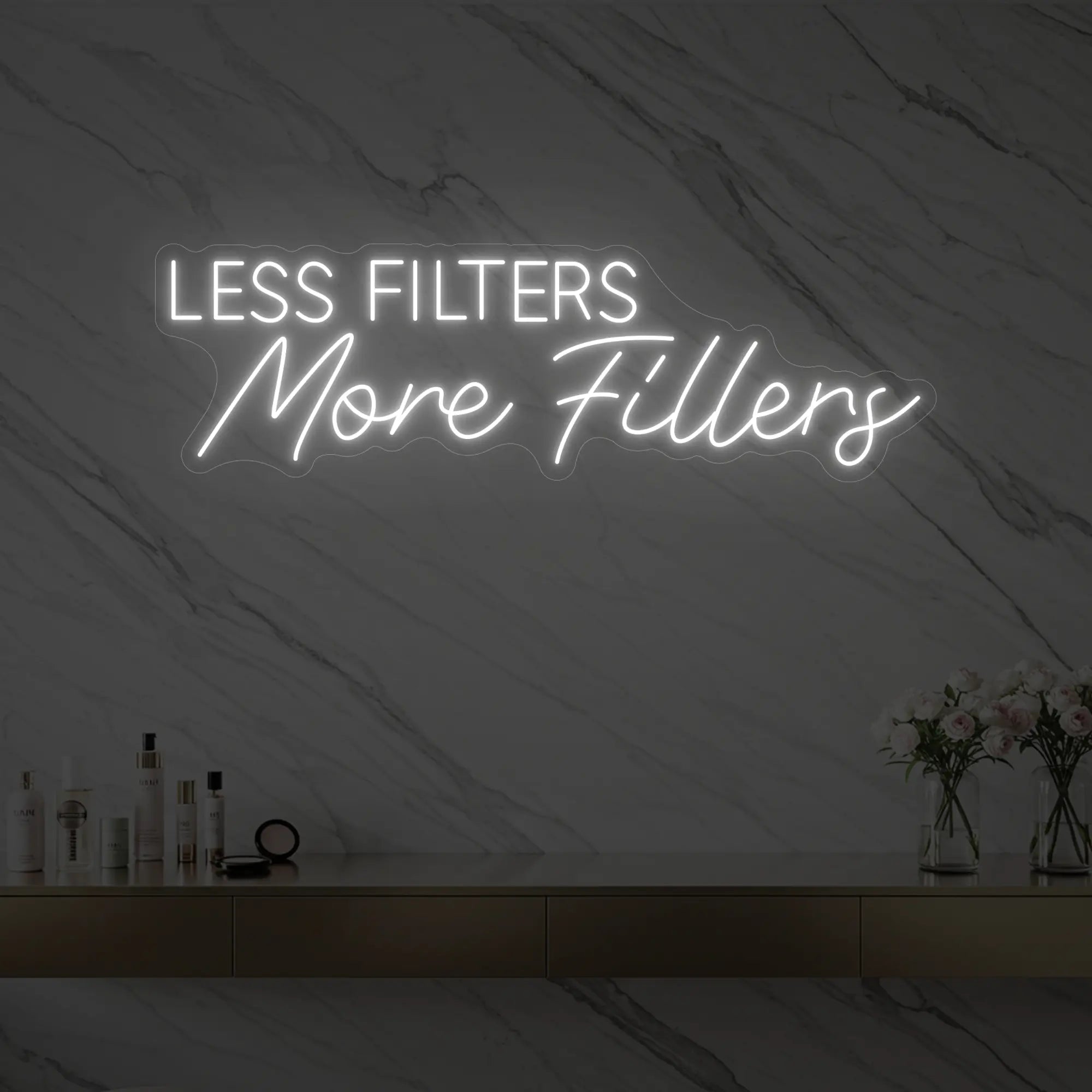 Photo of the 'LESS FILTERS MORE FILLERS' neon sign glowing in cool white against a marble wall.