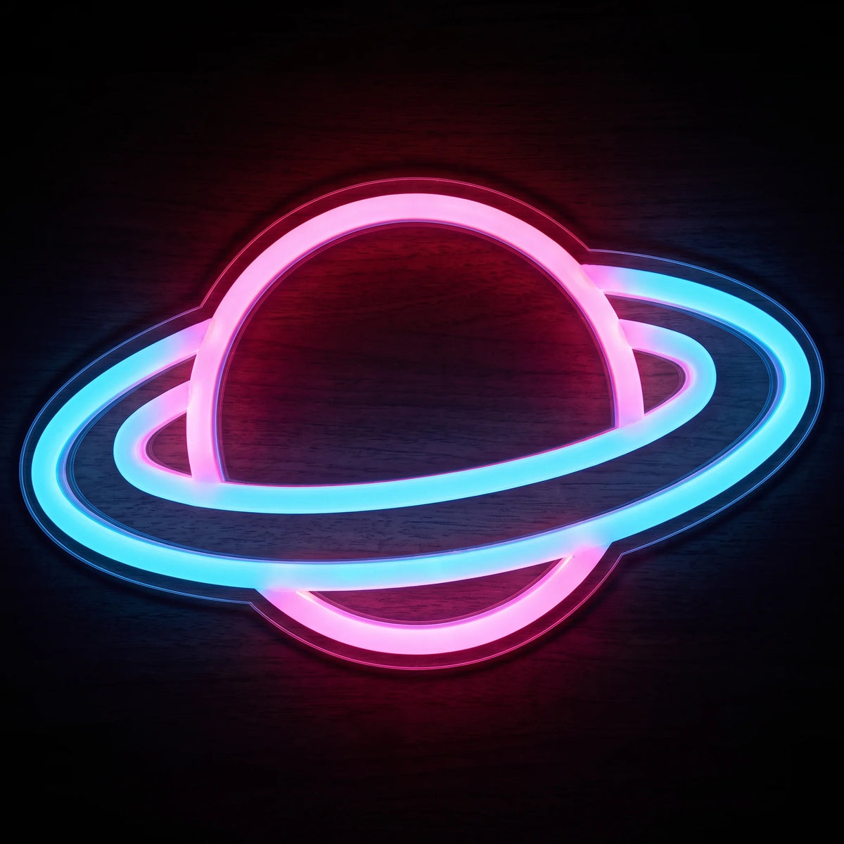 Neon ringed planet LED neon sign with vibrant pink and blue illumination on clear acrylic backing.