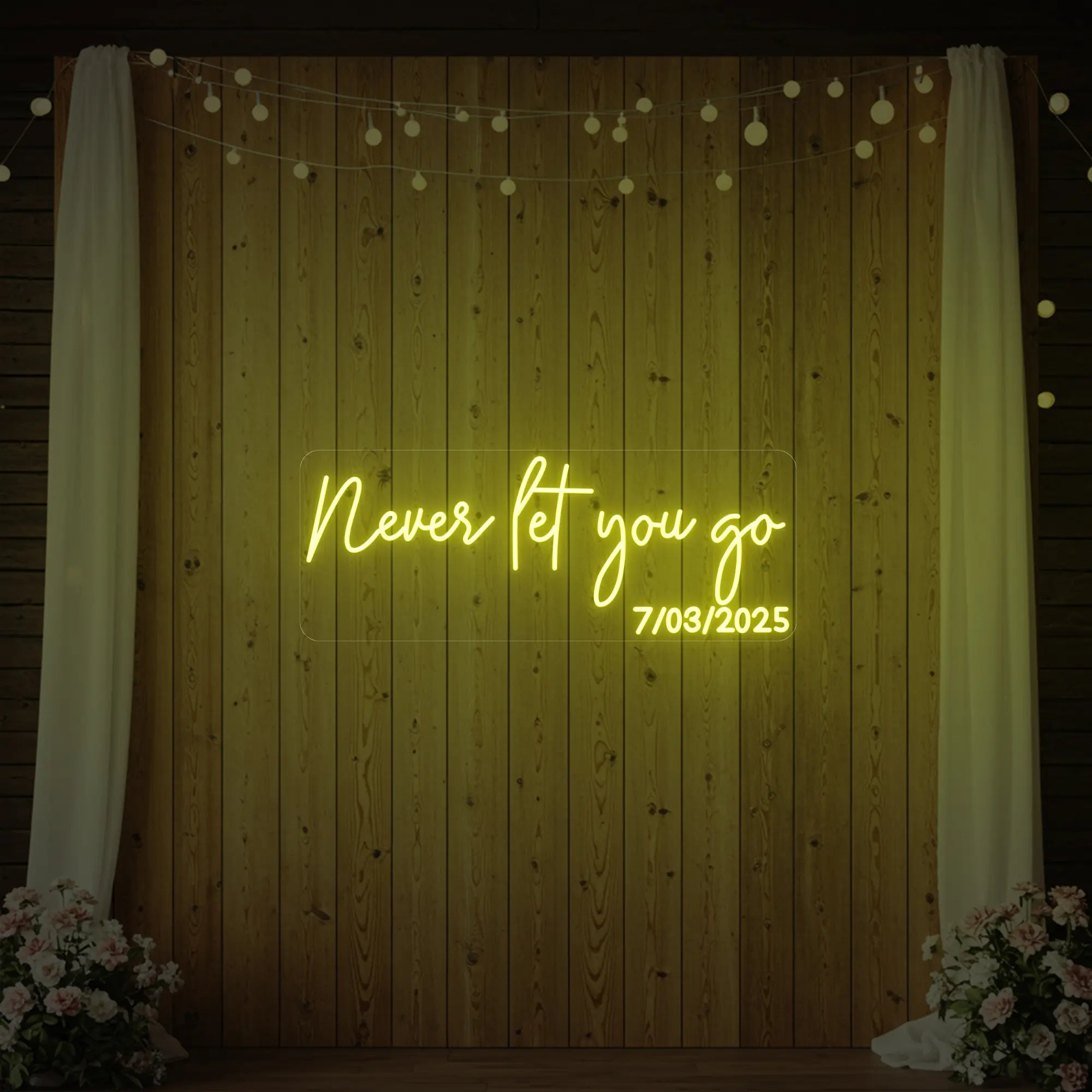 'Never Let You Go' neon sign glowing in lemon yellow against a styled interior wall.