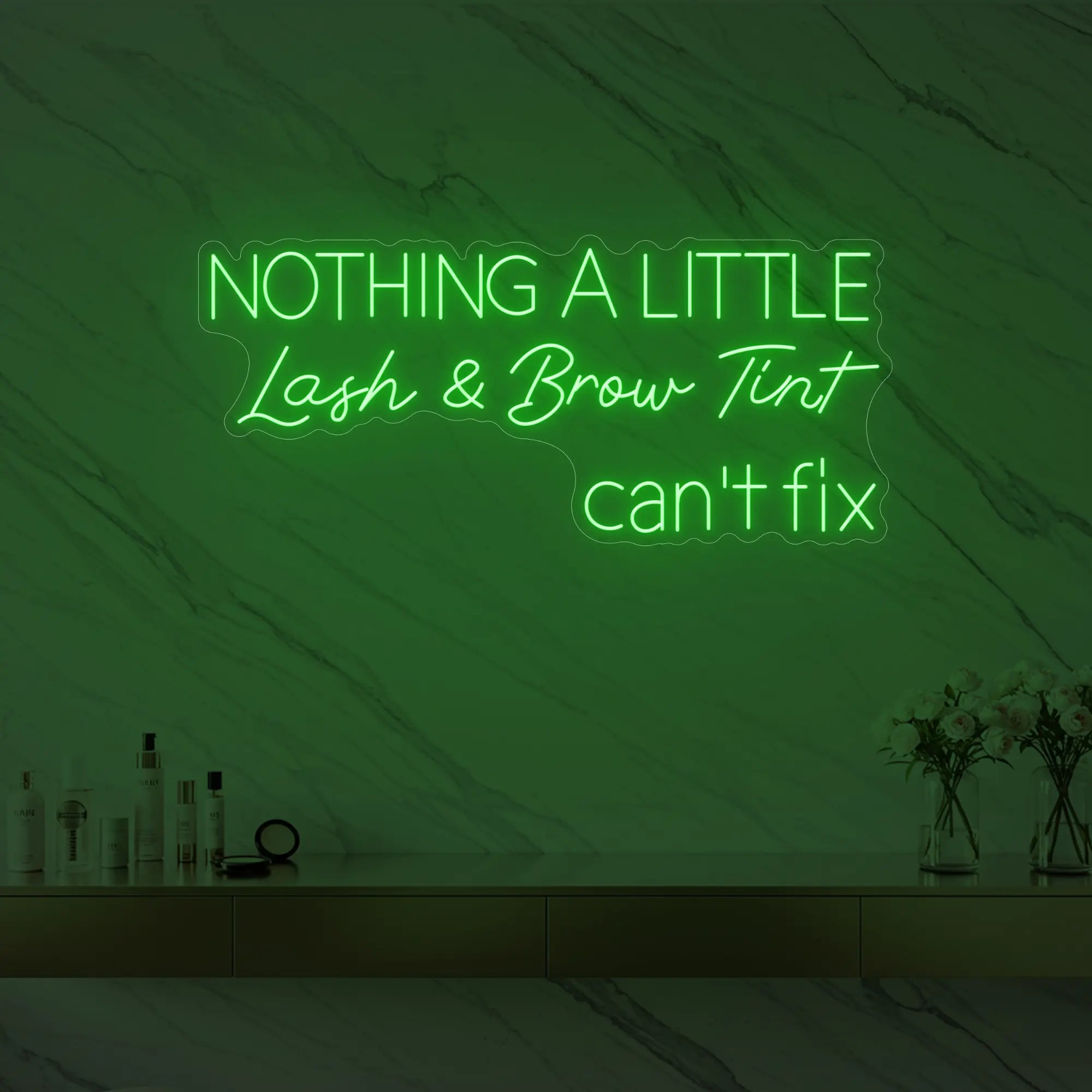 Photo of the 'Nothing a Little Lash & Brow Tint Can’t Fix' neon sign glowing in green against a styled interior wall.