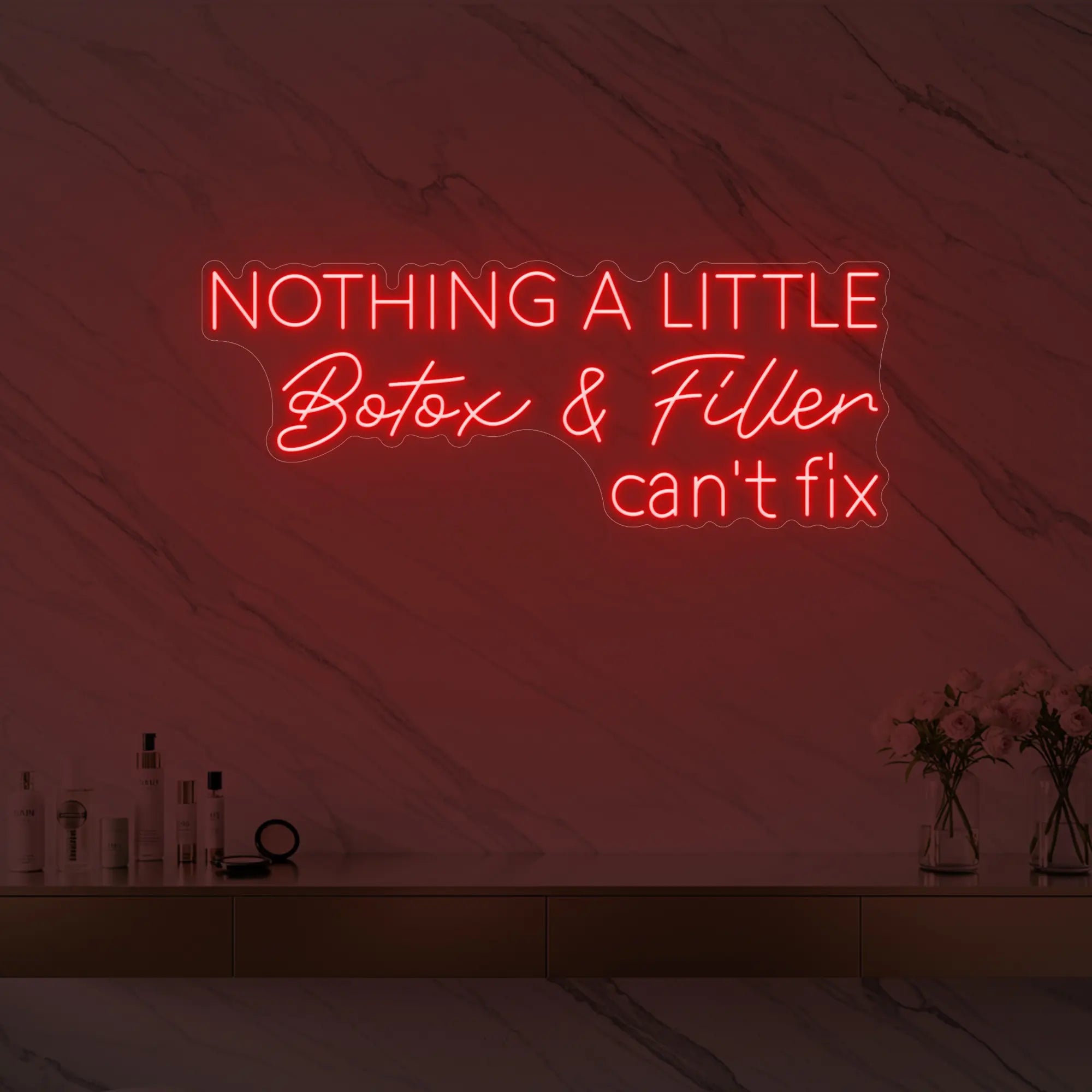 Photo of the 'Nothing a Little Botox & Filler Can’t Fix' neon sign glowing in red against a styled interior wall.