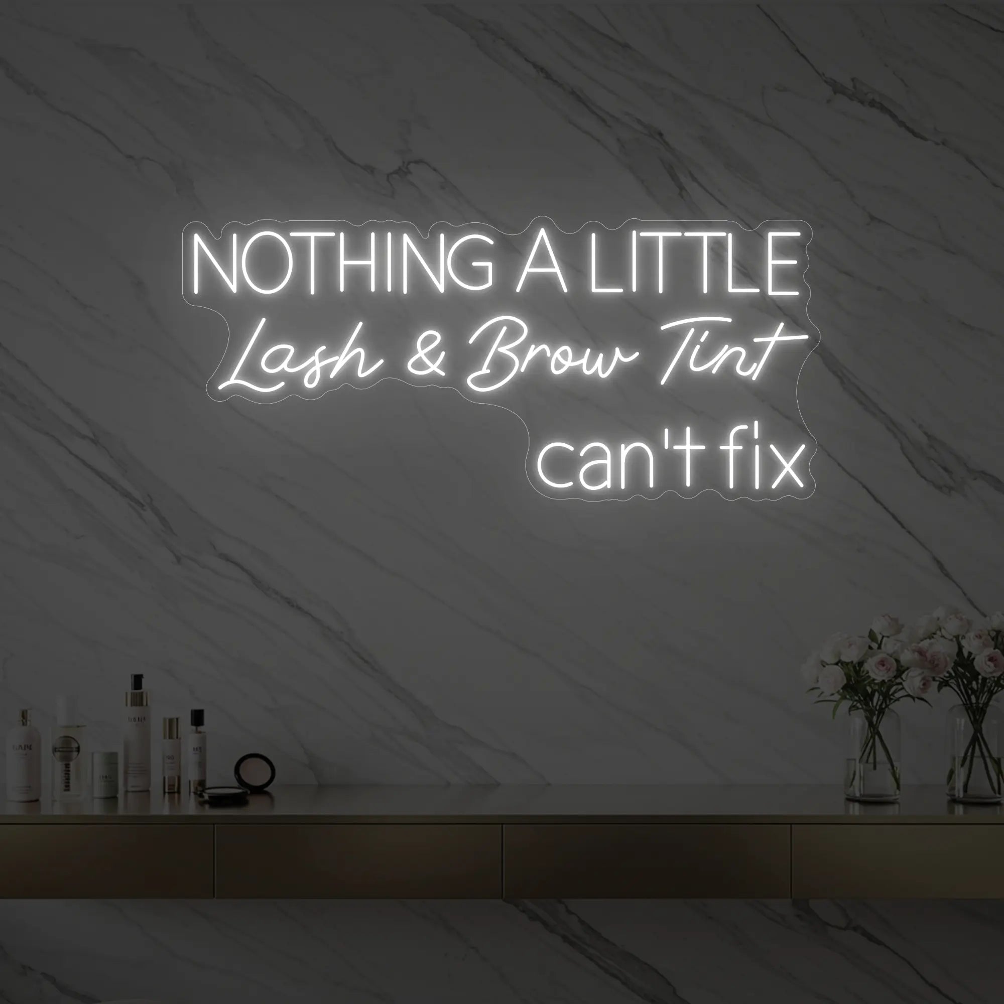 Photo of the 'Nothing a Little Lash & Brow Tint Can’t Fix' neon sign glowing in cool white against a styled interior wall.