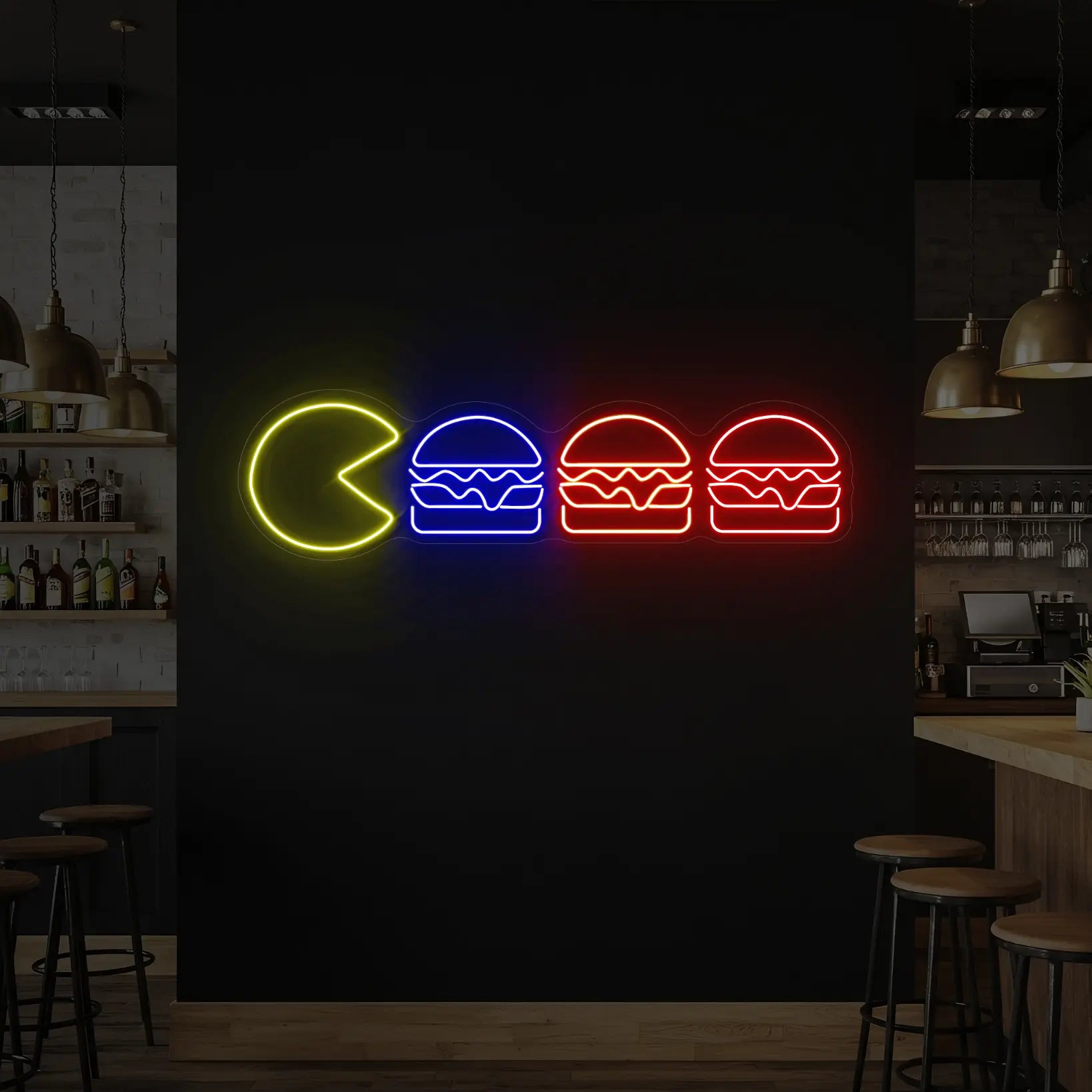 Photo of the 'Pac-Man Burgers' neon sign glowing in lemon yellow, deep blue, orange and red against a styled interior wall.