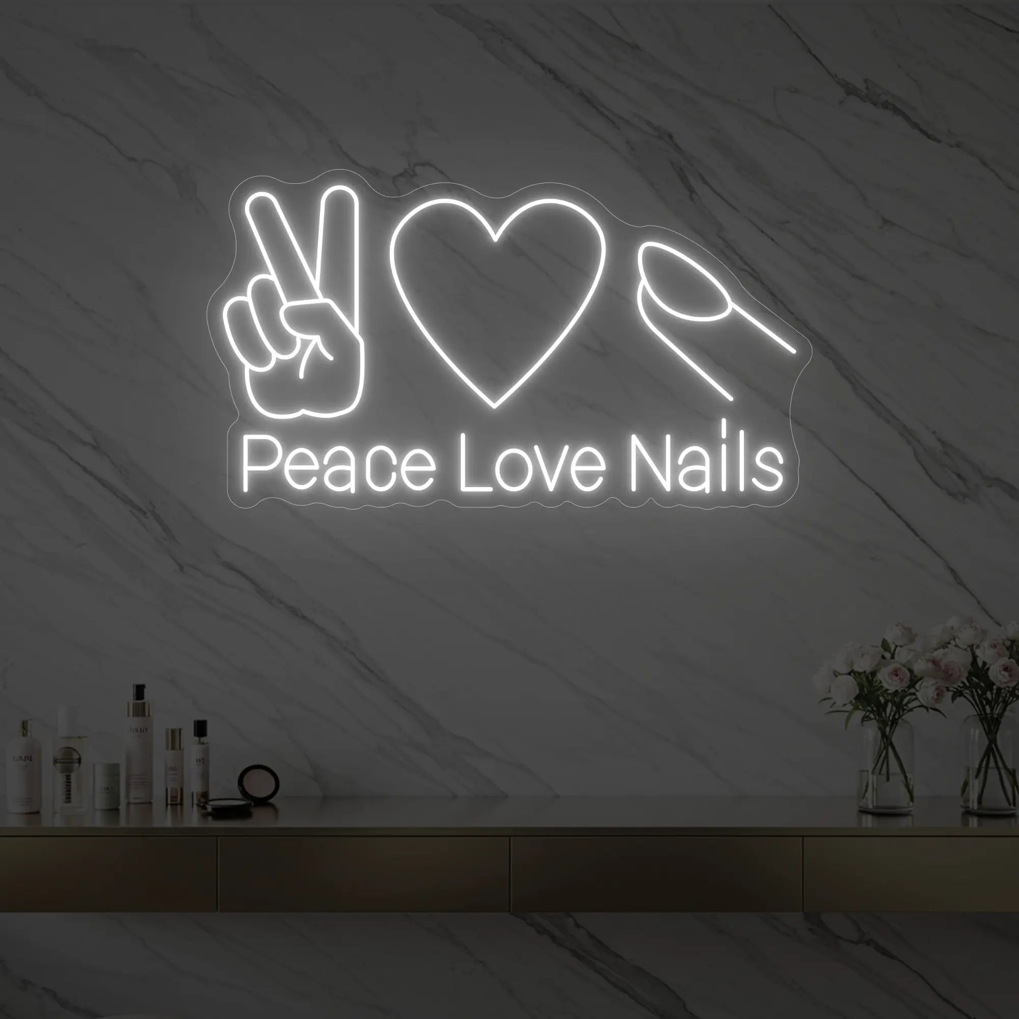 Photo of the 'Peace Love Nails' neon sign glowing in cool white against a styled interior wall.