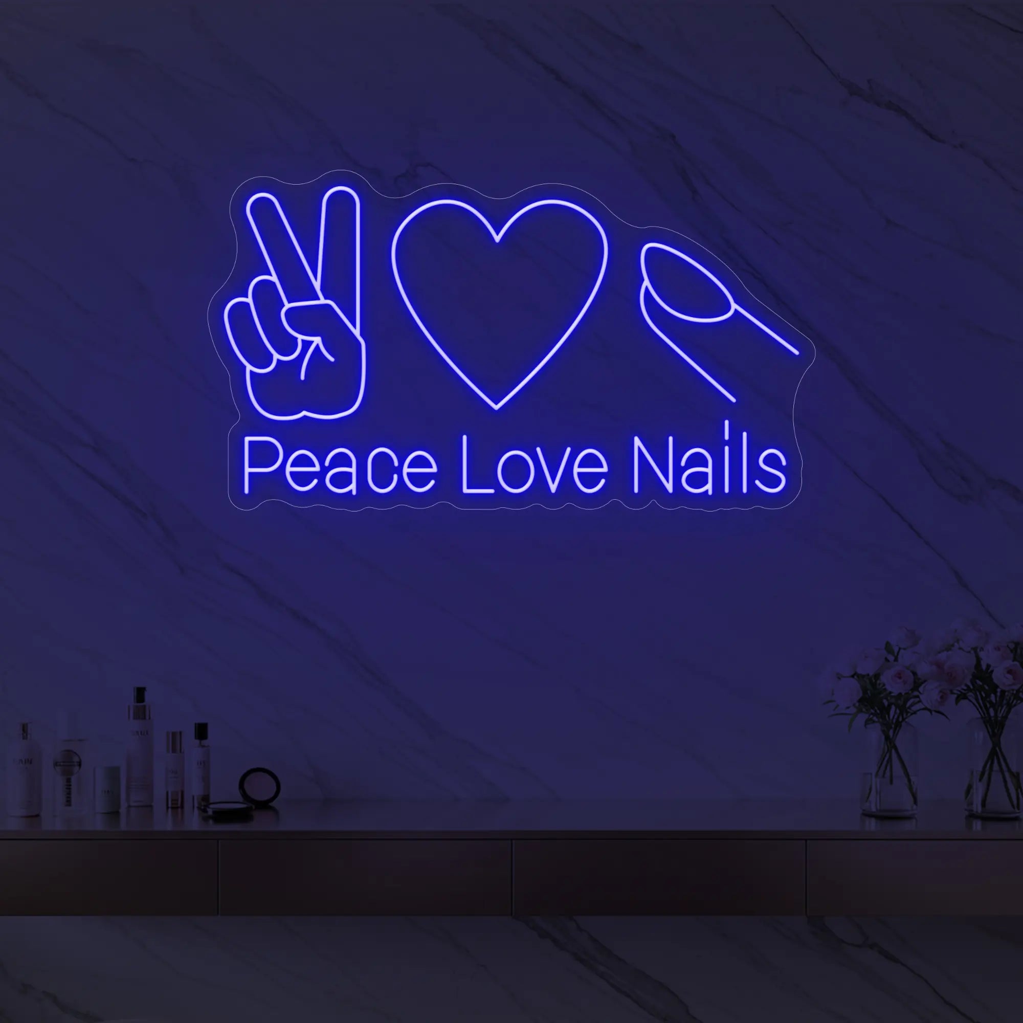 Photo of the 'Peace Love Nails' neon sign glowing in deep blue against a styled interior wall.