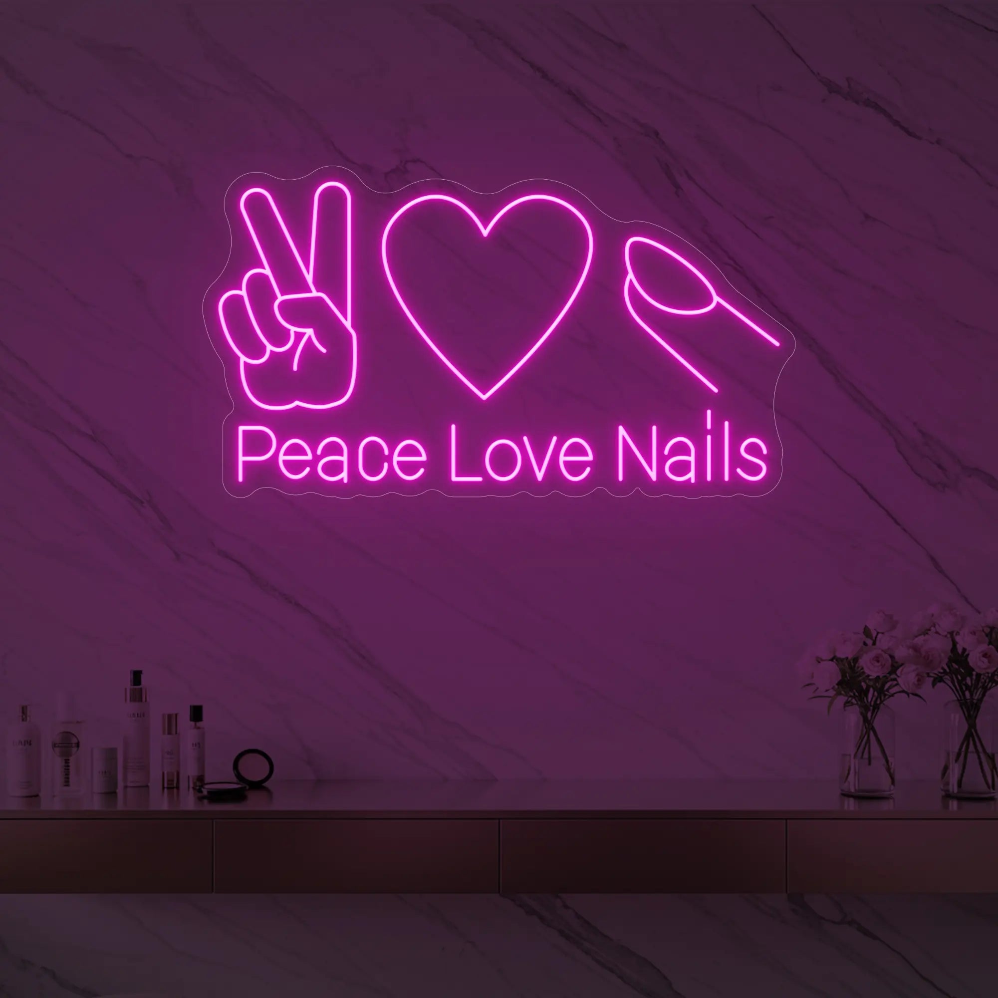 Photo of the 'Peace Love Nails' neon sign glowing in light pink against a styled interior wall.