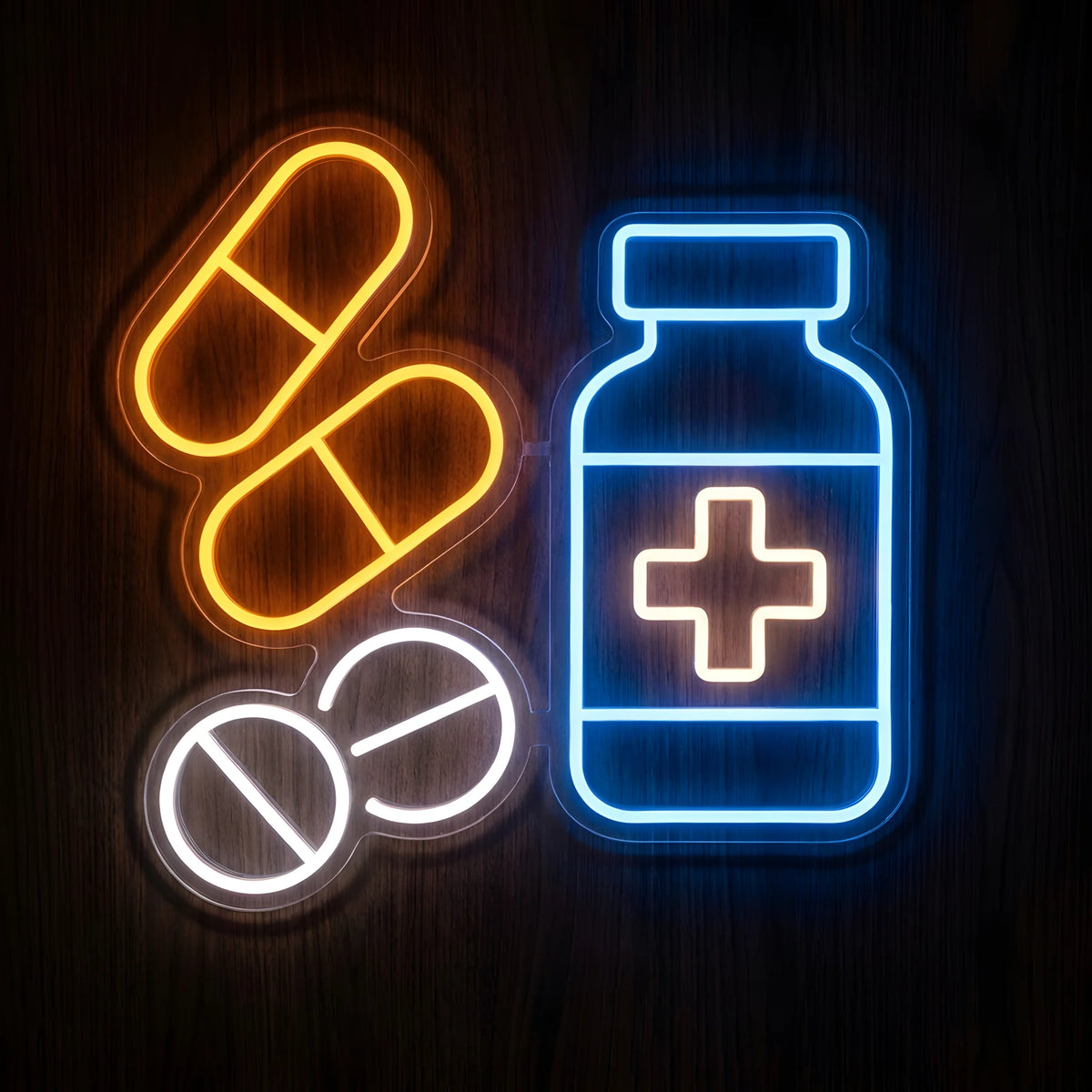 Pharmacy Prescription Medicine LED Neon Sign featuring a glowing blue medicine bottle with a white medical cross, two orange capsules, and two white tablets on clear acrylic against a dark wooden wall.