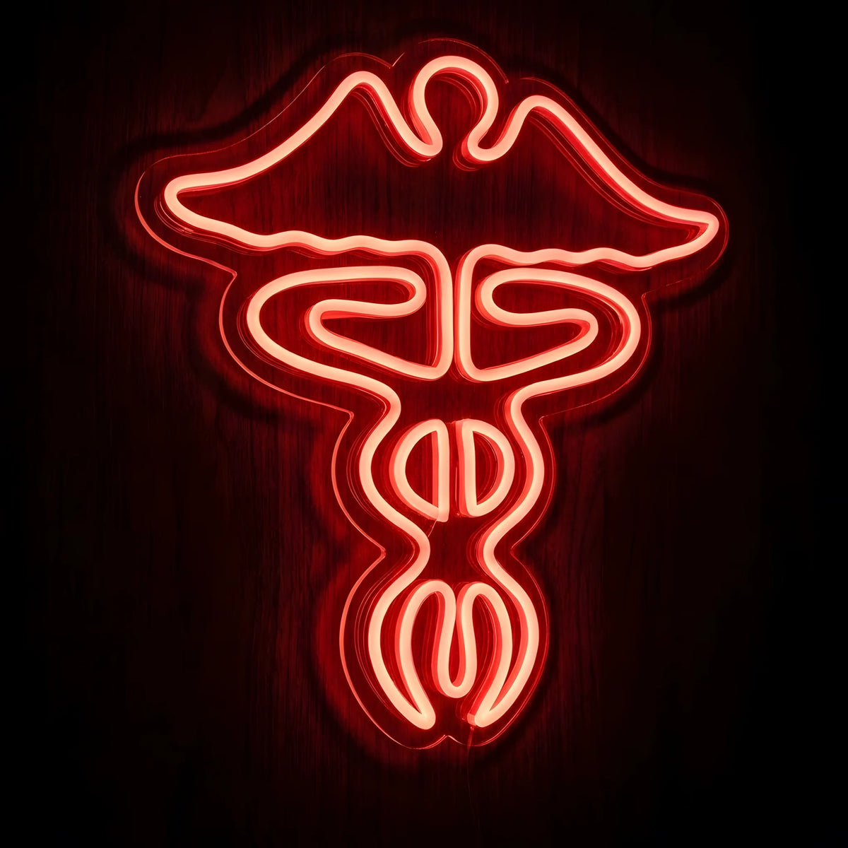 Red Caduceus Medical Symbol LED Neon Sign featuring a glowing red winged medical emblem with intertwined serpents on clear cut-to-shape acrylic backing against a dark wooden wall.