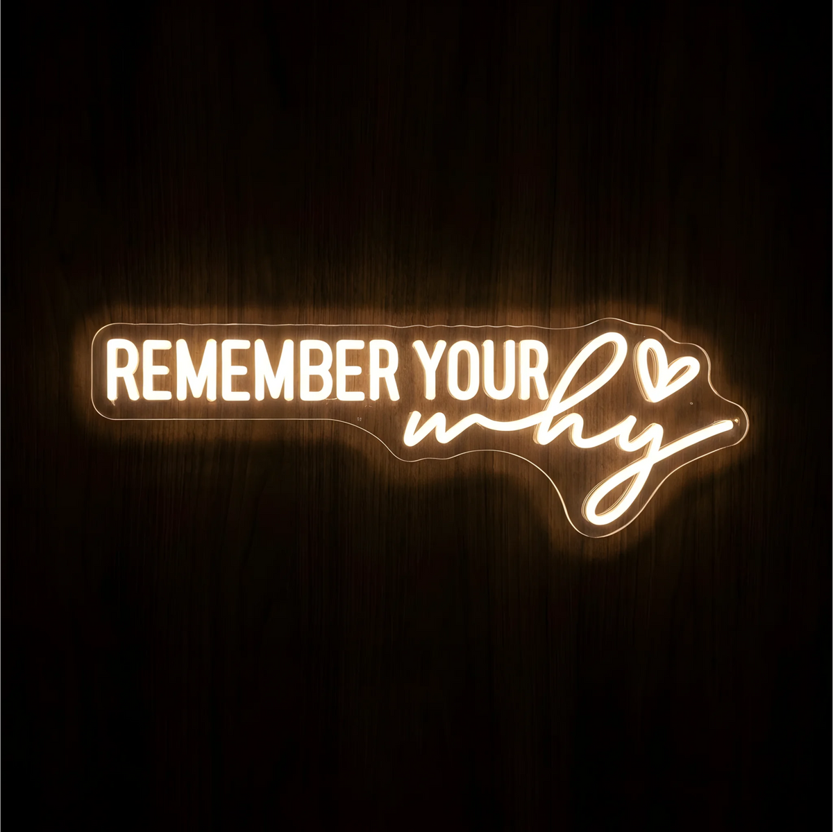 βREMEMBER YOUR whyβ LED Neon Sign glowing in warm white, with uppercase lettering, the word βwhyβ in script, and a small outlined heart on clear acrylic against a dark wood background, suited to home offices and workspaces.