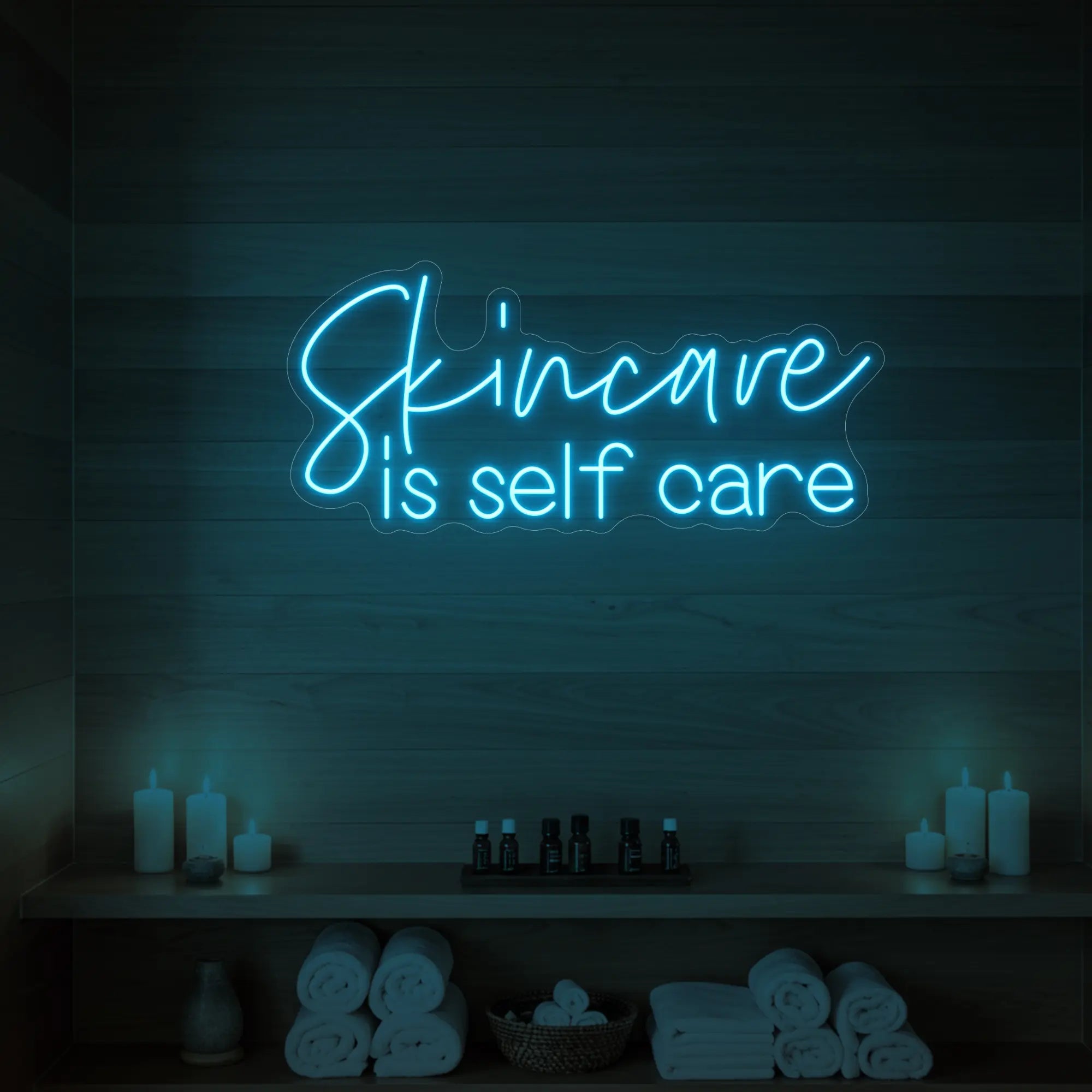 Photo of the 'Skincare is Self Care' neon sign glowing in ice blue against a styled interior wall.
