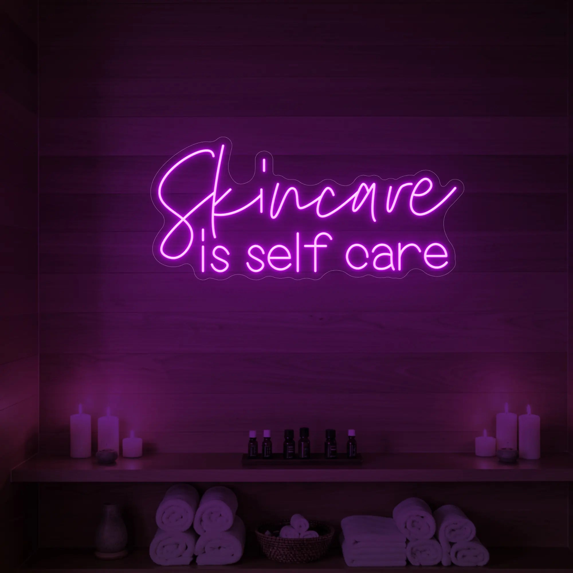 Photo of the 'Skincare is Self Care' neon sign glowing in deep pink against a styled interior wall.