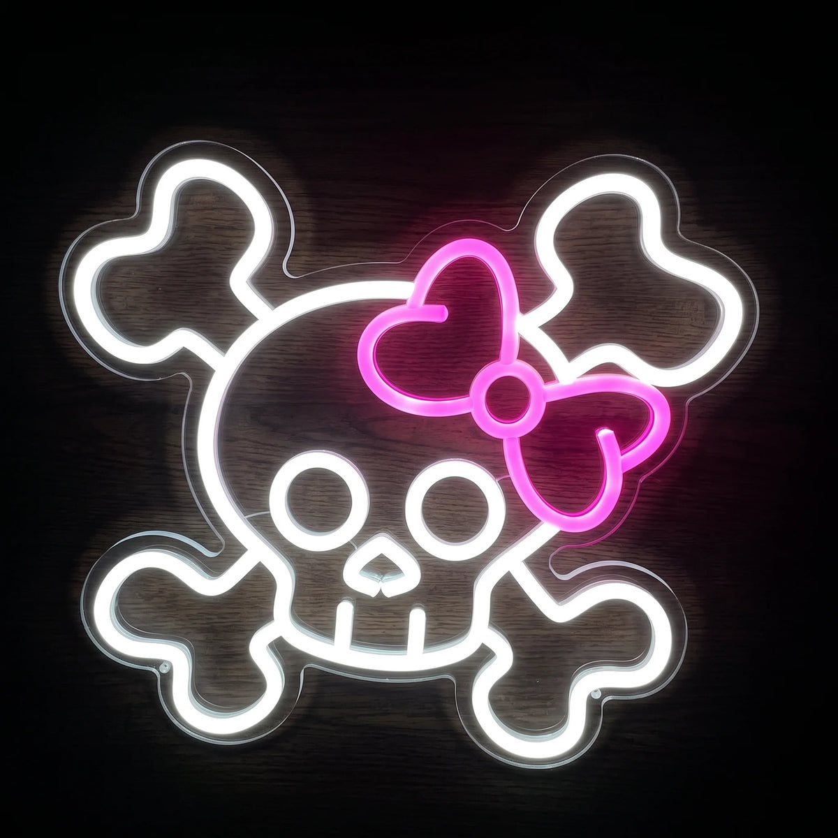 Skull Bow LED neon sign with white skull and crossbones and bright pink bow on clear acrylic backing.