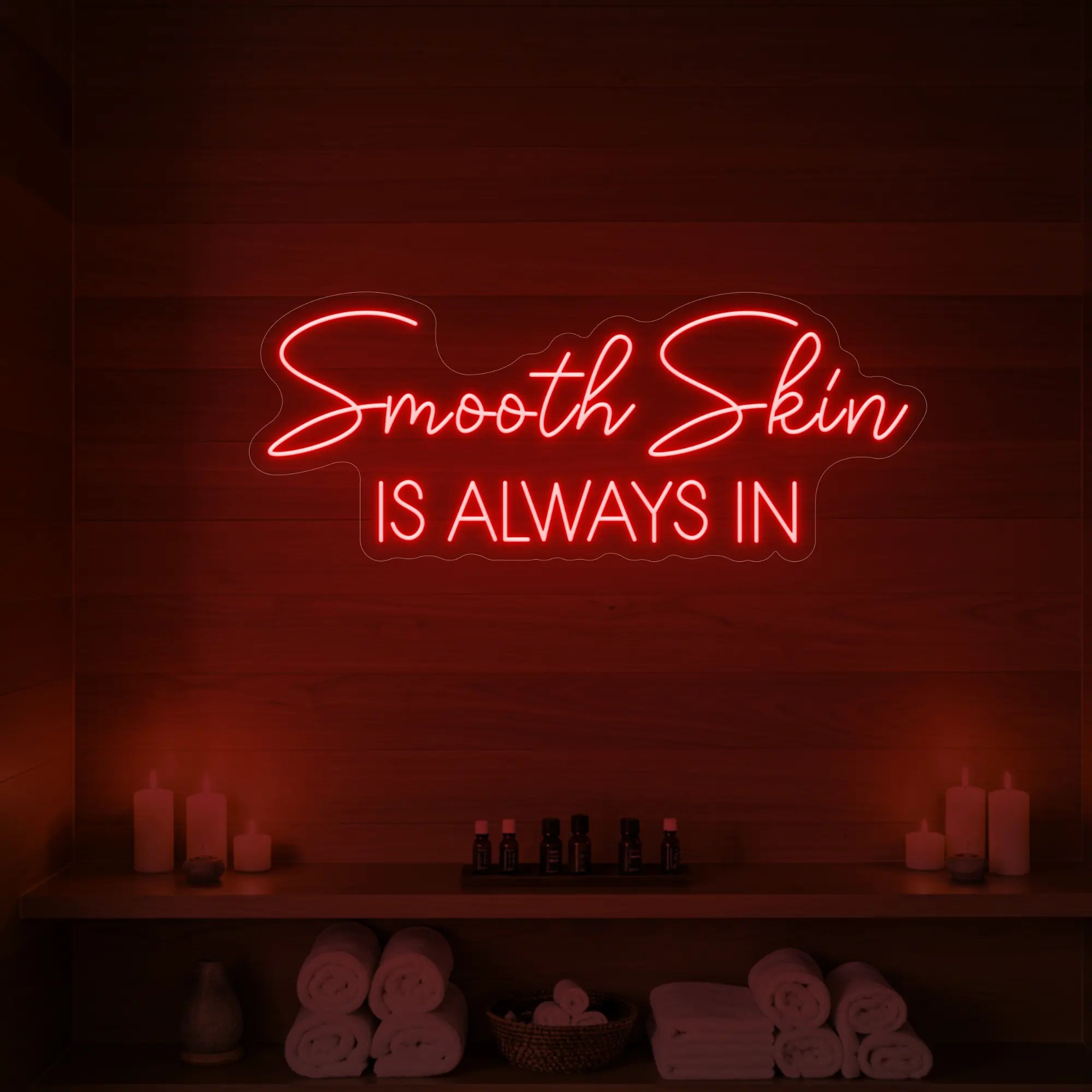 Photo of the 'Smooth Skin Is Always In' neon sign glowing in red against a styled interior wall.