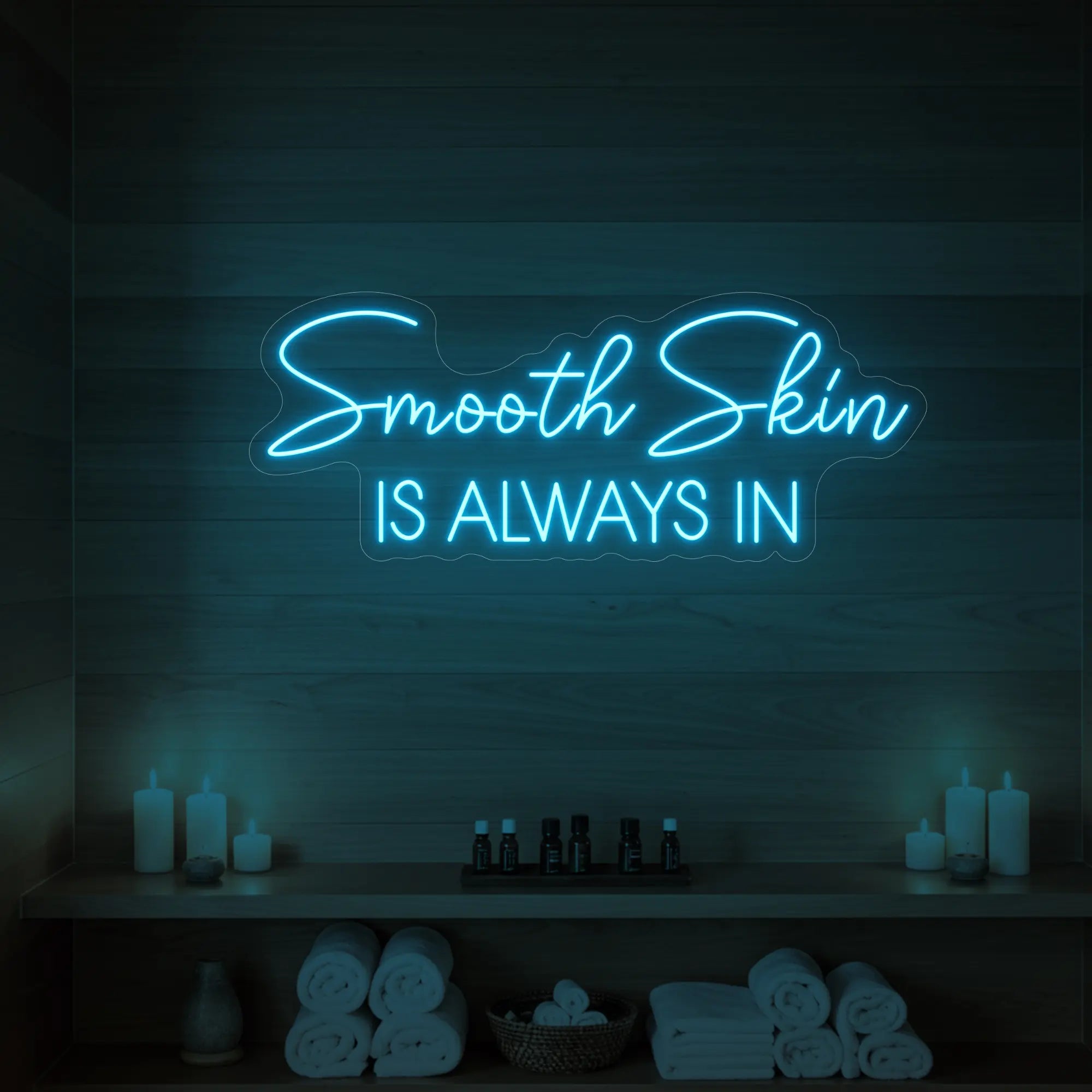 Photo of the 'Smooth Skin Is Always In' neon sign glowing in ice blue against a styled interior wall.