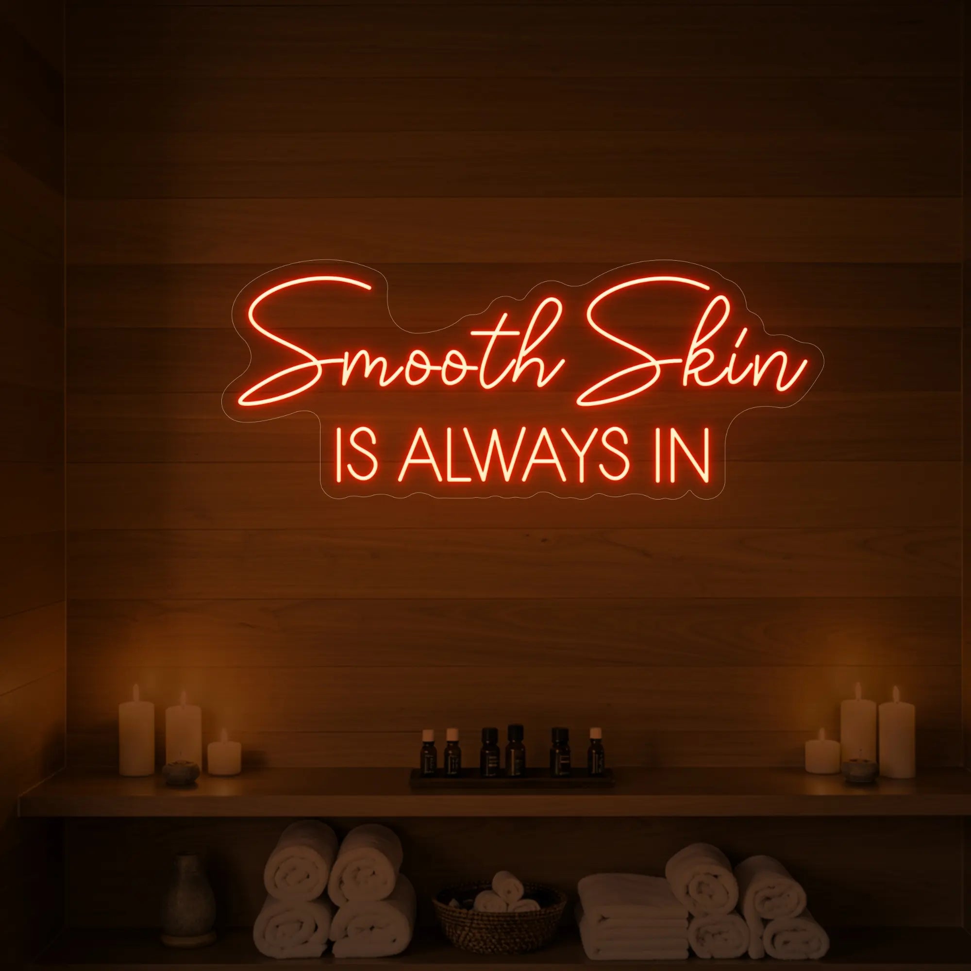 Photo of the 'Smooth Skin Is Always In' neon sign glowing in golden yellow against a styled interior wall.