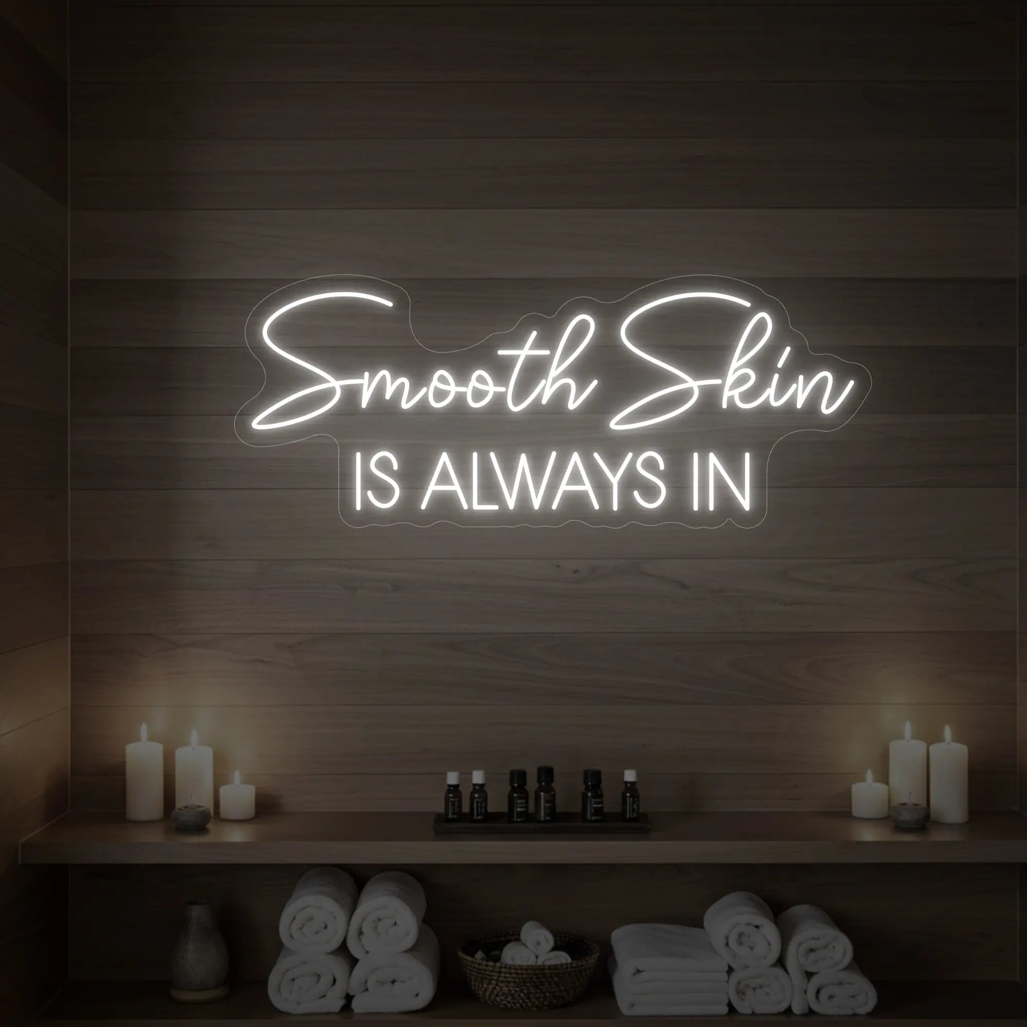Photo of the 'Smooth Skin Is Always In' neon sign glowing in cool white against a styled interior wall.