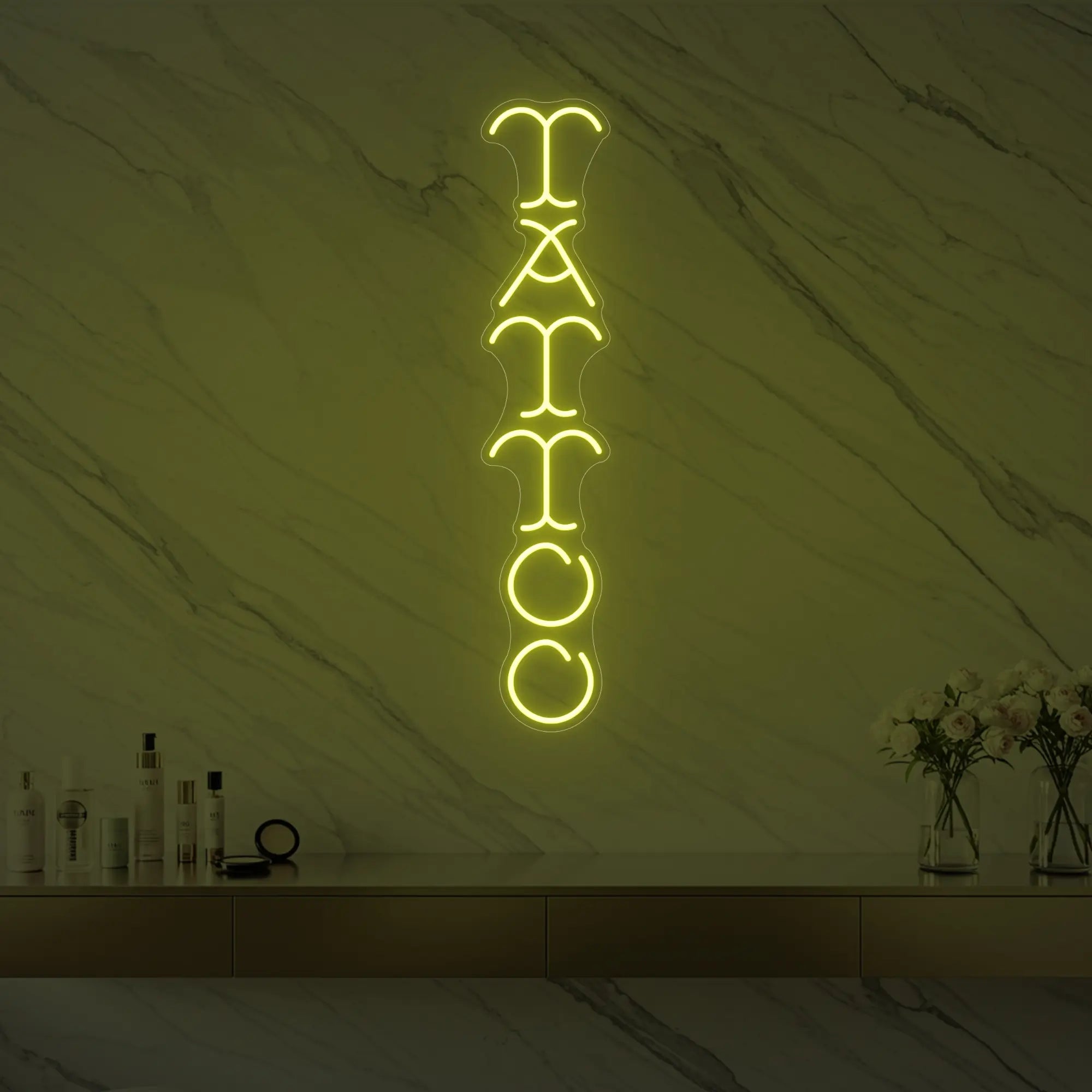 Photo of the 'Vertical Tattoo' neon sign glowing in lemon yellow against a styled interior wall.