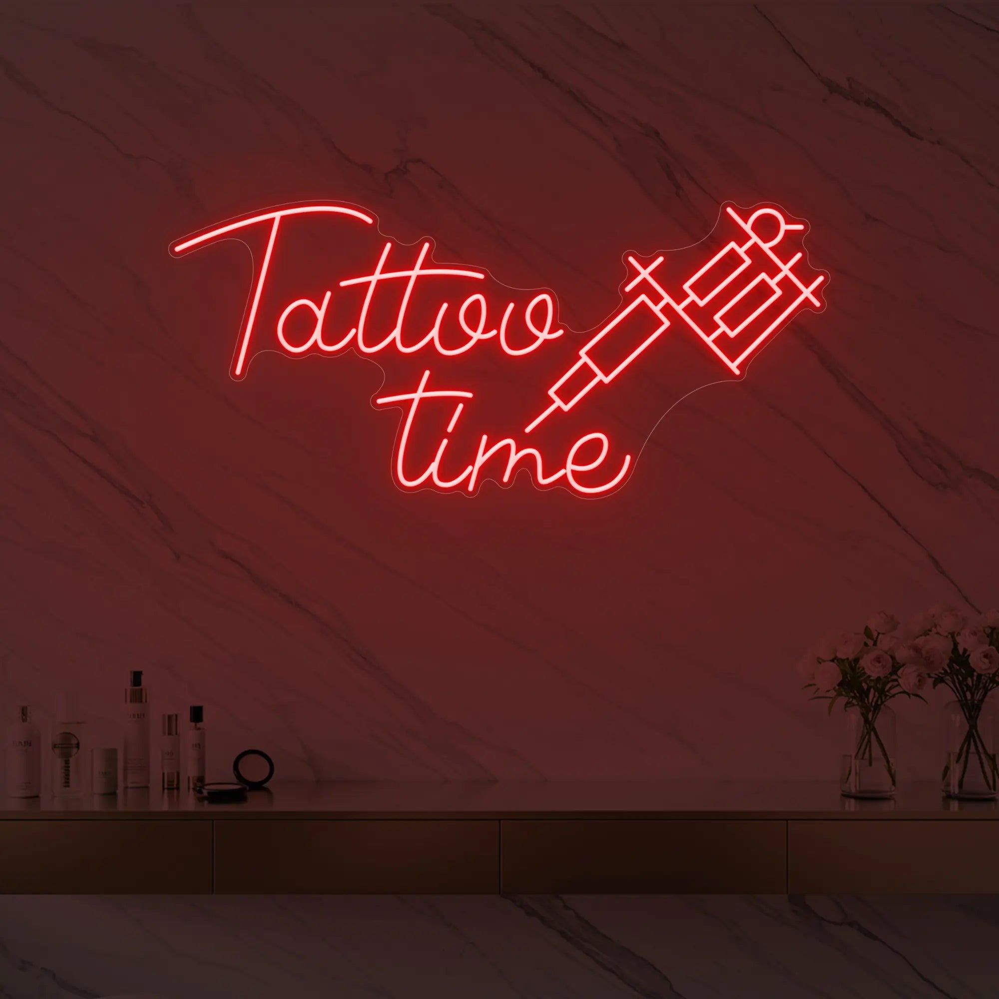 Photo of the 'Tattoo Time' neon sign glowing in red against a styled interior wall.