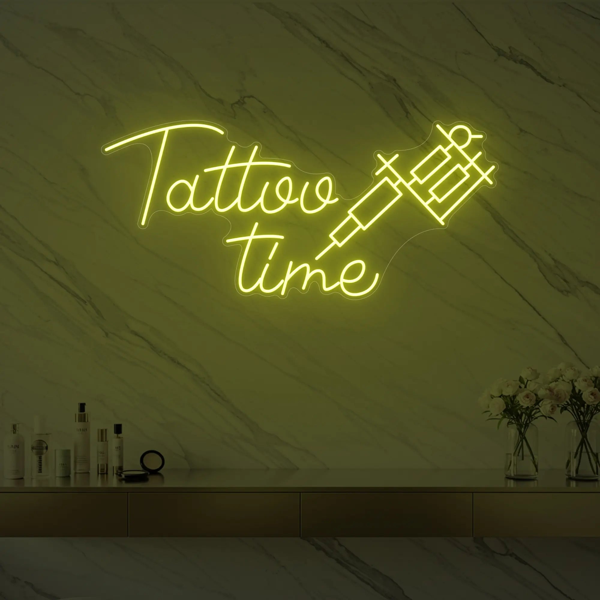 Photo of the 'Tattoo Time' neon sign glowing in lemon yellow against a styled interior wall.