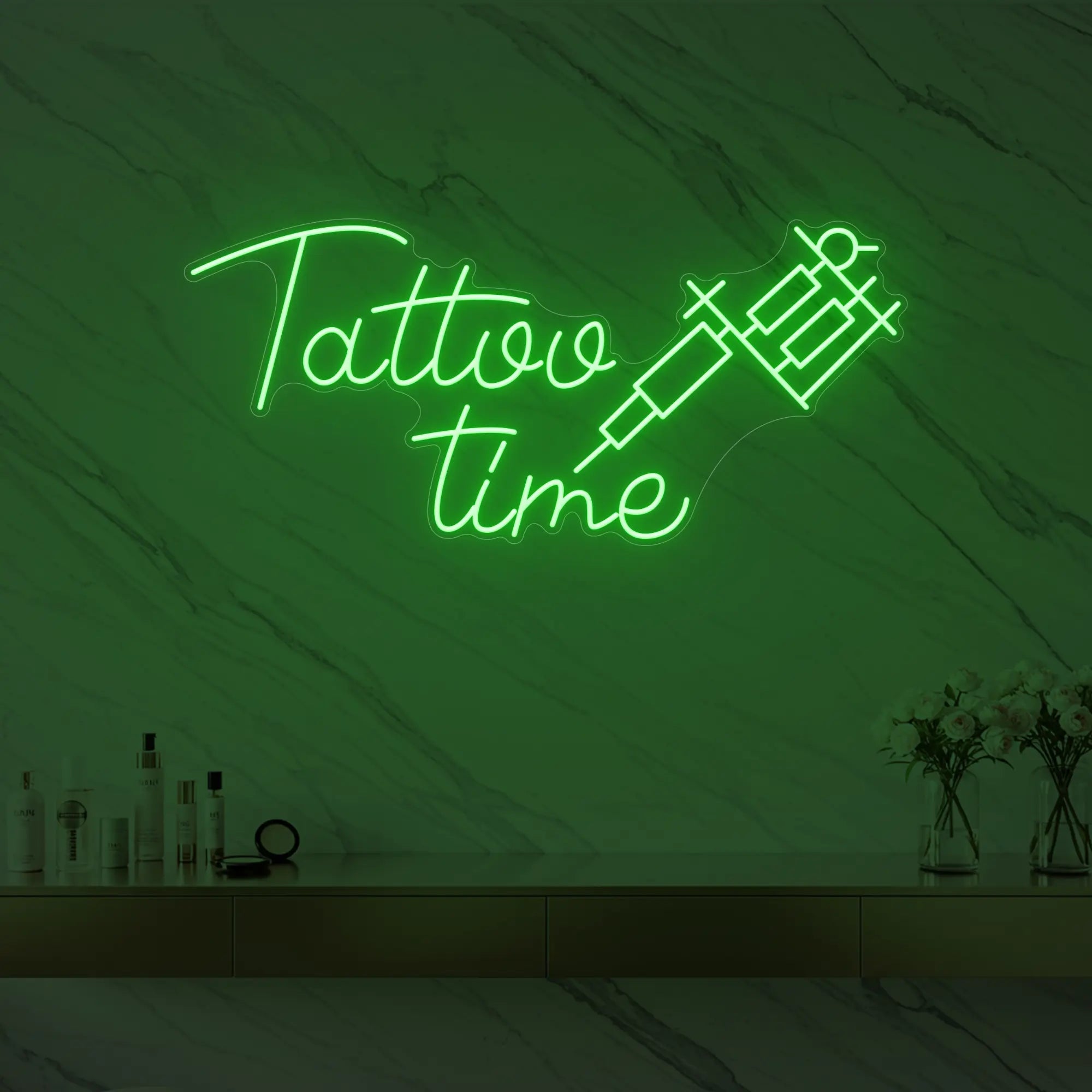 Photo of the 'Tattoo Time' neon sign glowing in green against a styled interior wall.