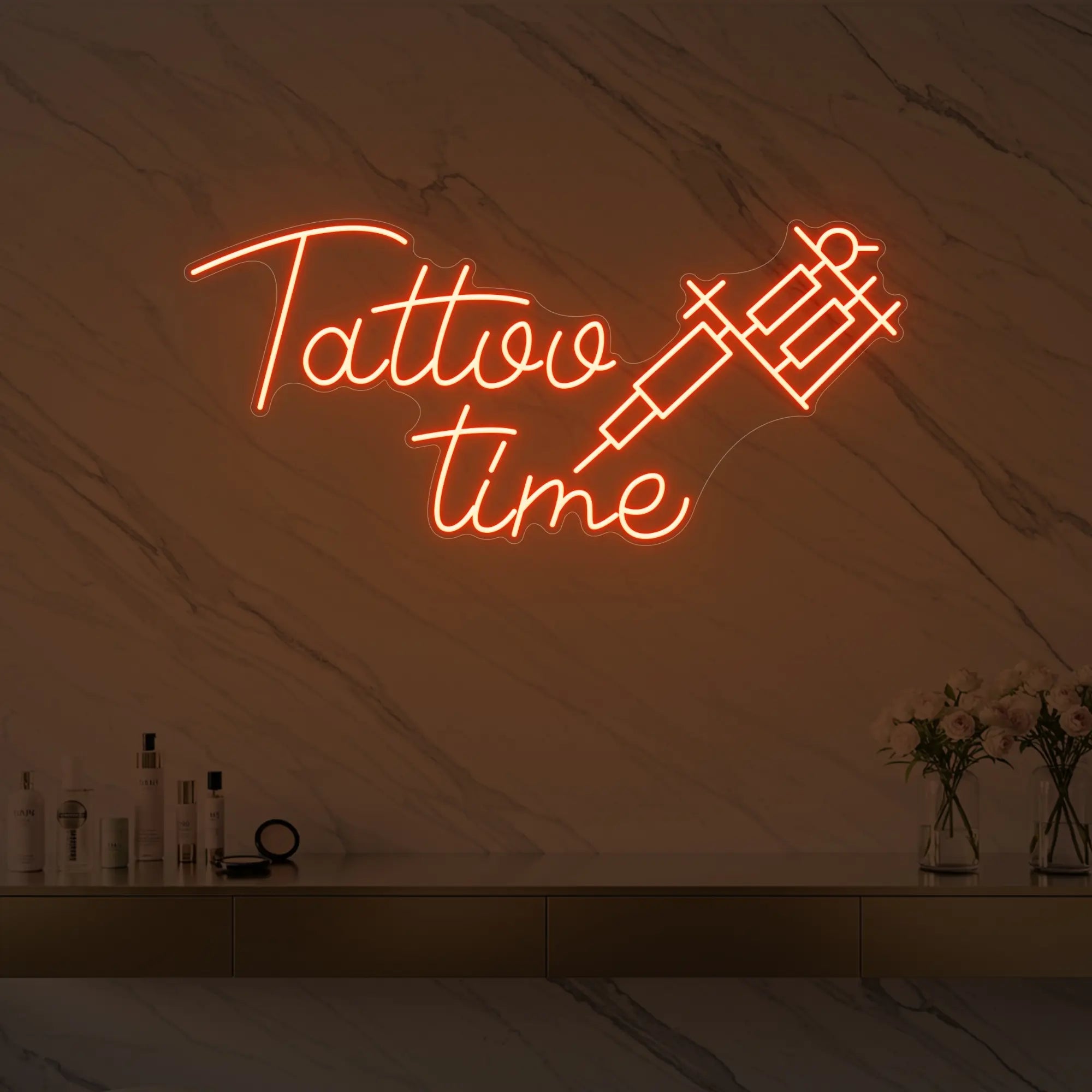 Photo of the 'Tattoo Time' neon sign glowing in golden yellow against a styled interior wall.