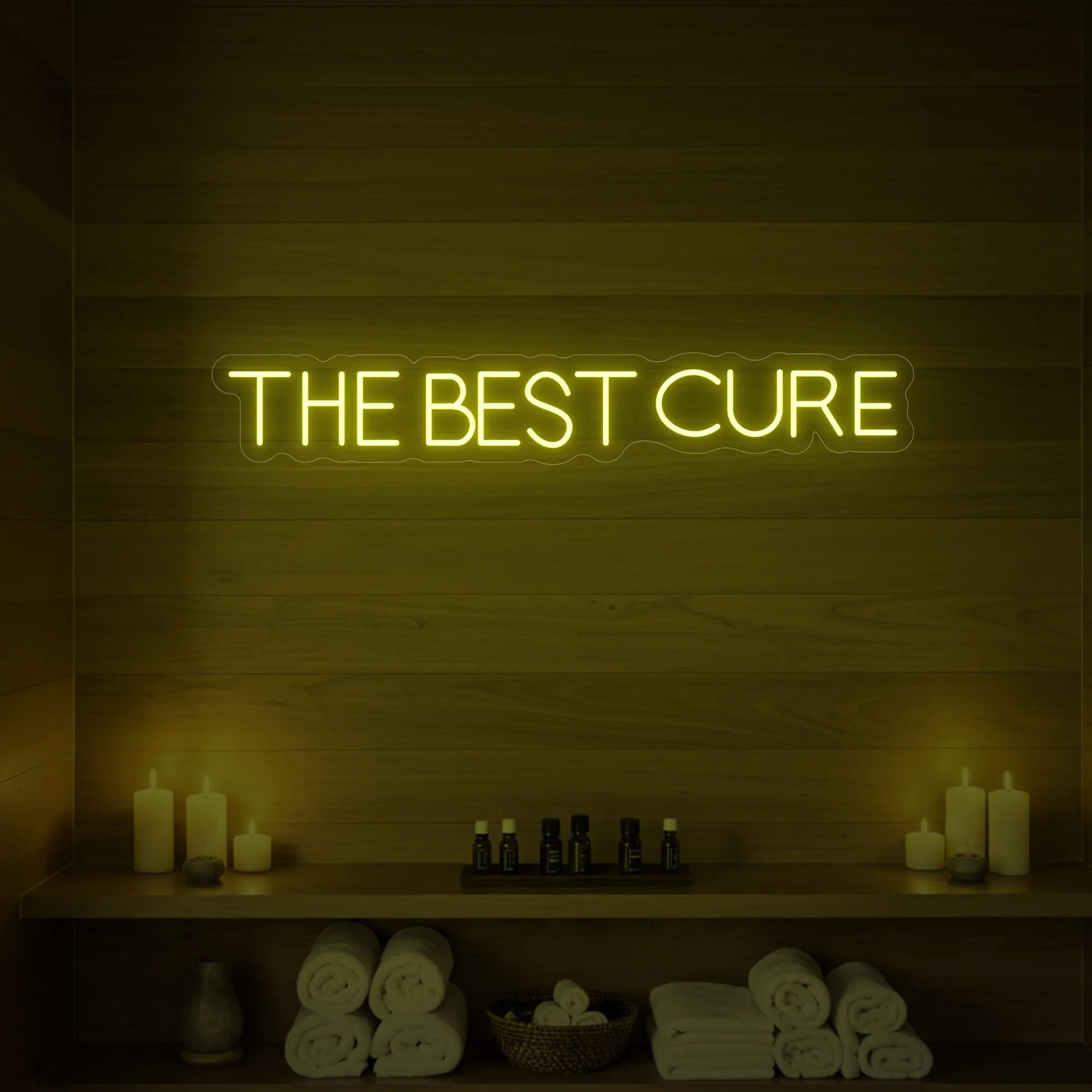 Photo of the 'The Best Cure' neon sign glowing in lemon yellow against a styled interior wall.