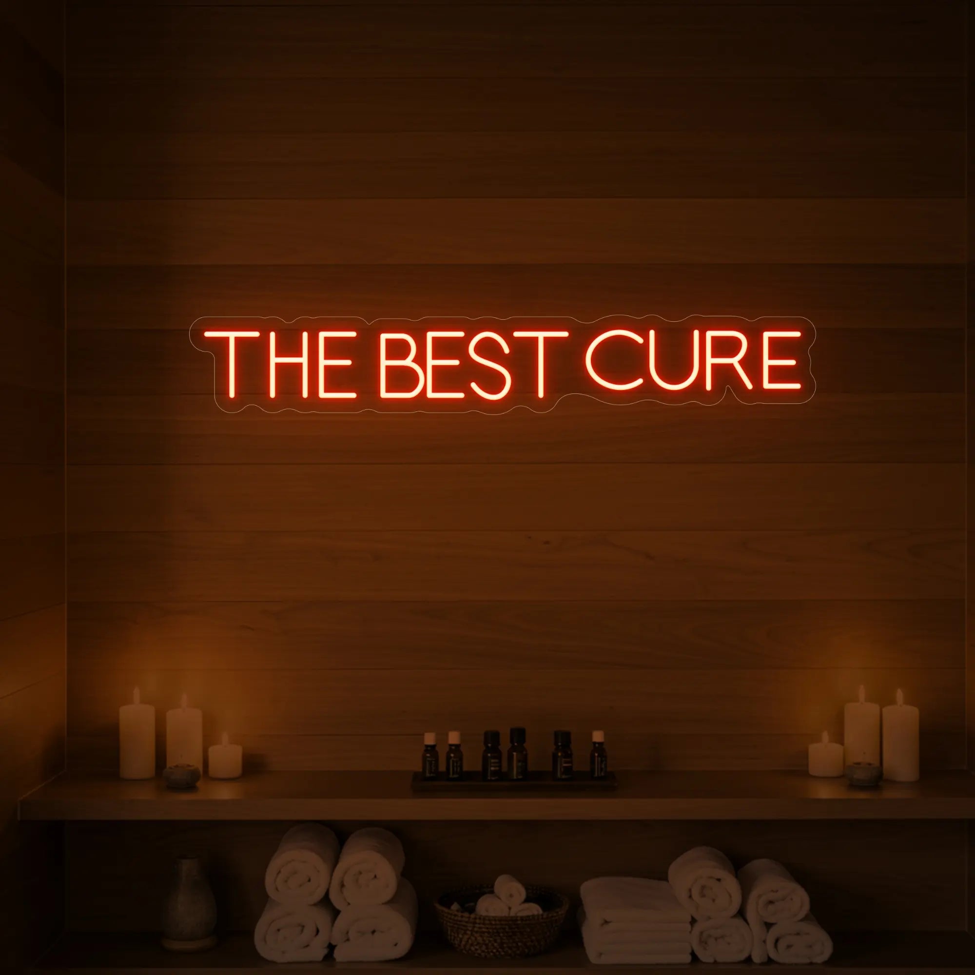 Photo of the 'The Best Cure' neon sign glowing in golden yellow against a styled interior wall.