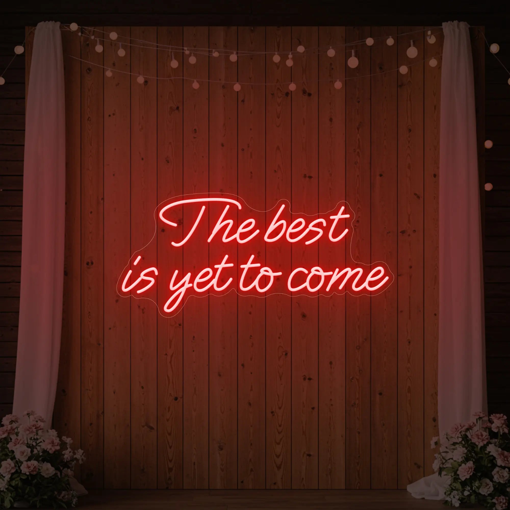 'The Best Is Yet To Come' neon sign glowing in red against a styled interior wall.