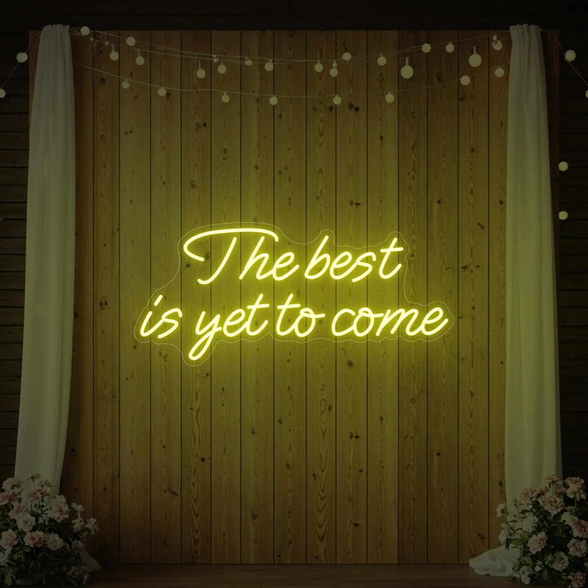 'The Best Is Yet To Come' neon sign glowing in lemon yellow against a styled interior wall.